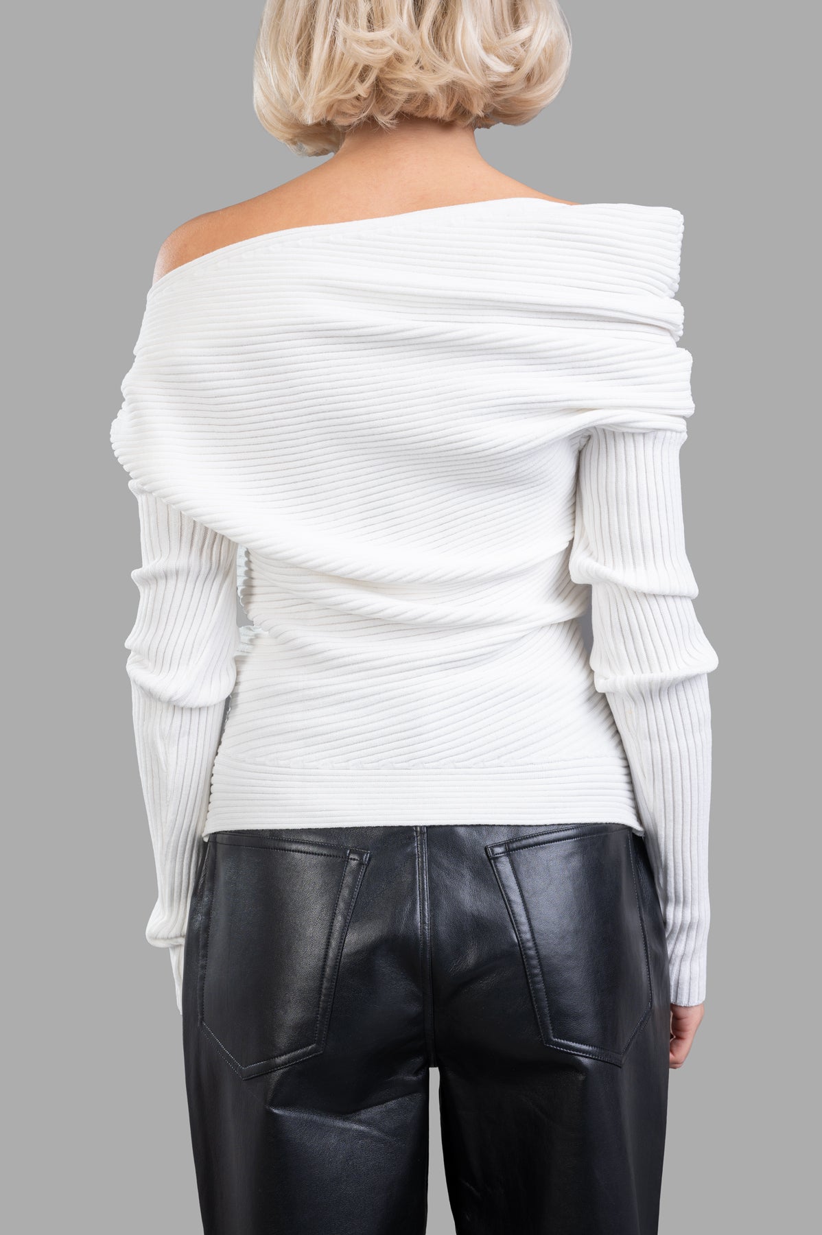 A.W.A.K.E. MODE Off-the-shoulder Sweater shown from the back, featuring a rib-knit texture and asymmetrical neckline in.