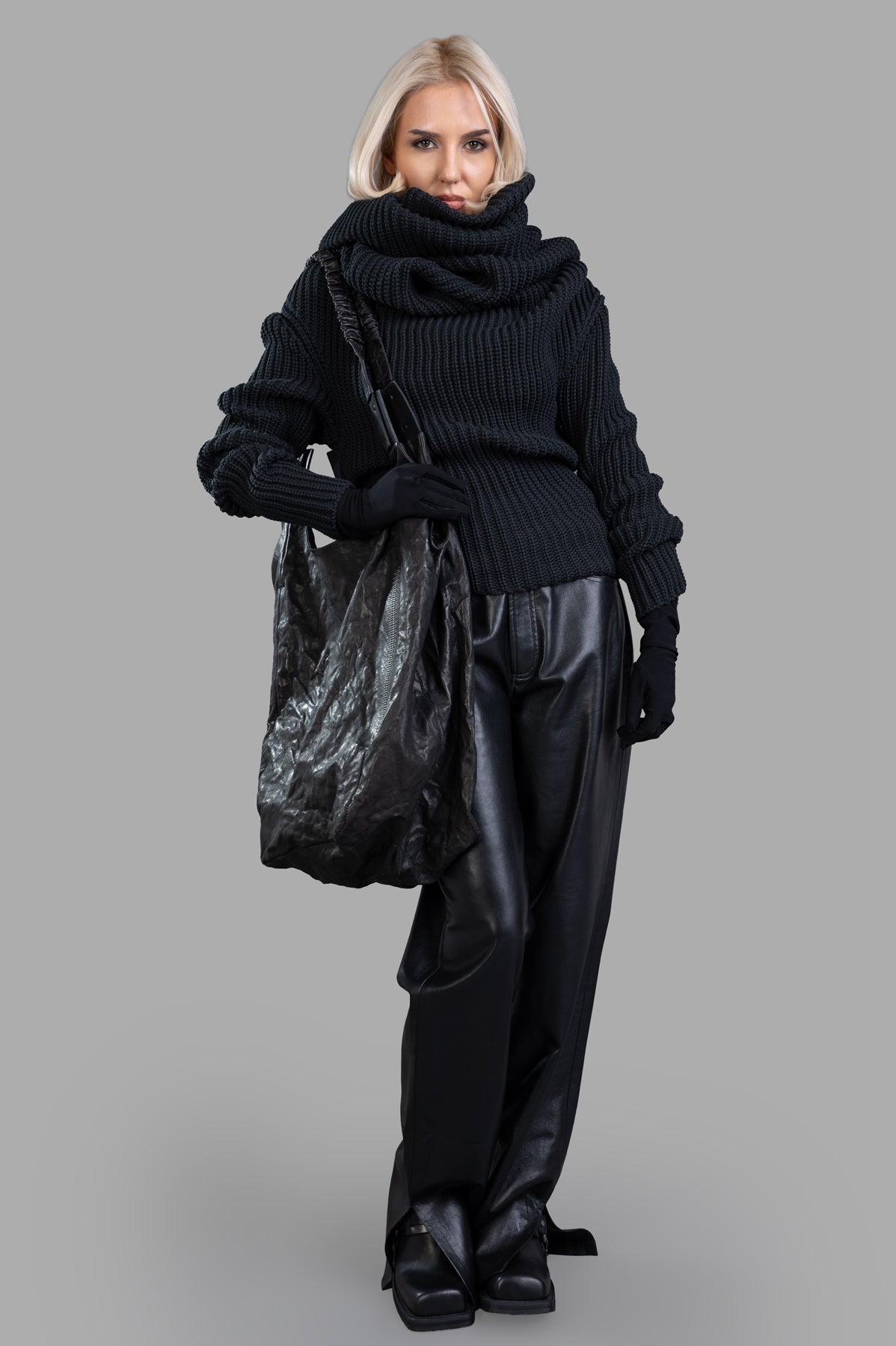 A.W.A.K.E. MODE Knit Top With Gloves, front view, cozy hooded design, relaxed chest, slim waist, model holding bag.
