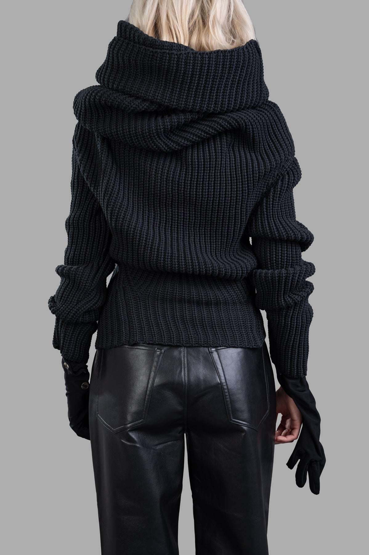 A.W.A.K.E. MODE Knit Top With Gloves, showcasing its stylish hood and unique glove feature, captured in a side profile on a.