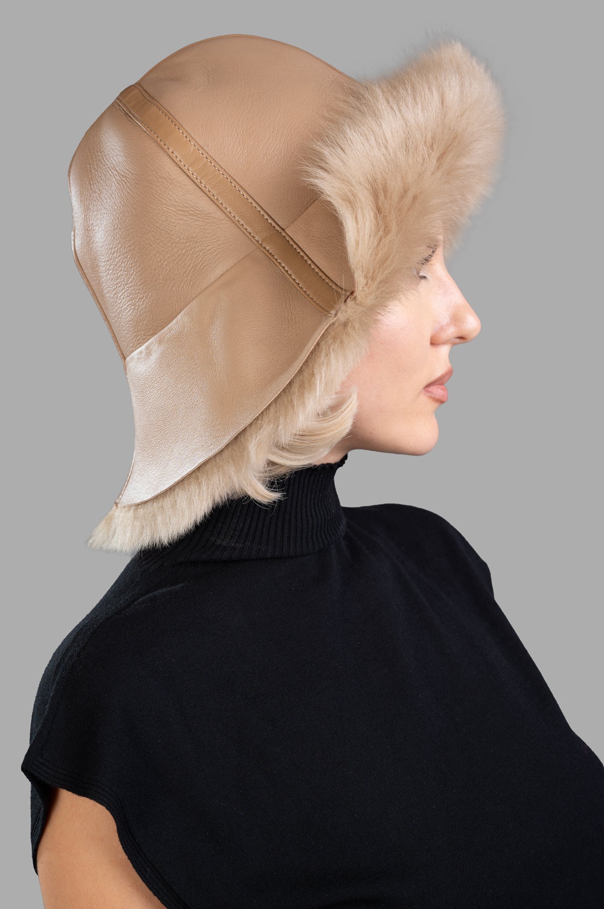 By Malene Birger Reversible Leather Bucket Hat shown from the side, featuring beige shearling trim and soft leather texture.