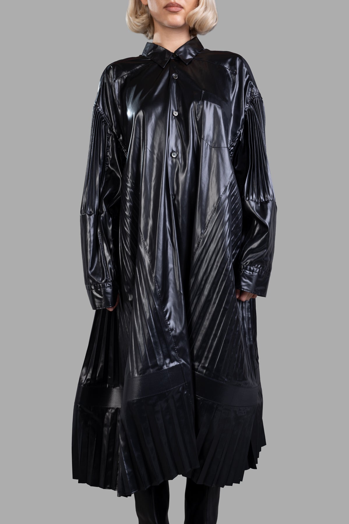 Junya Watanabe Pleated Dress in black, featuring metallic pleat detailing, buttoned cuffs, and front pocket on model.