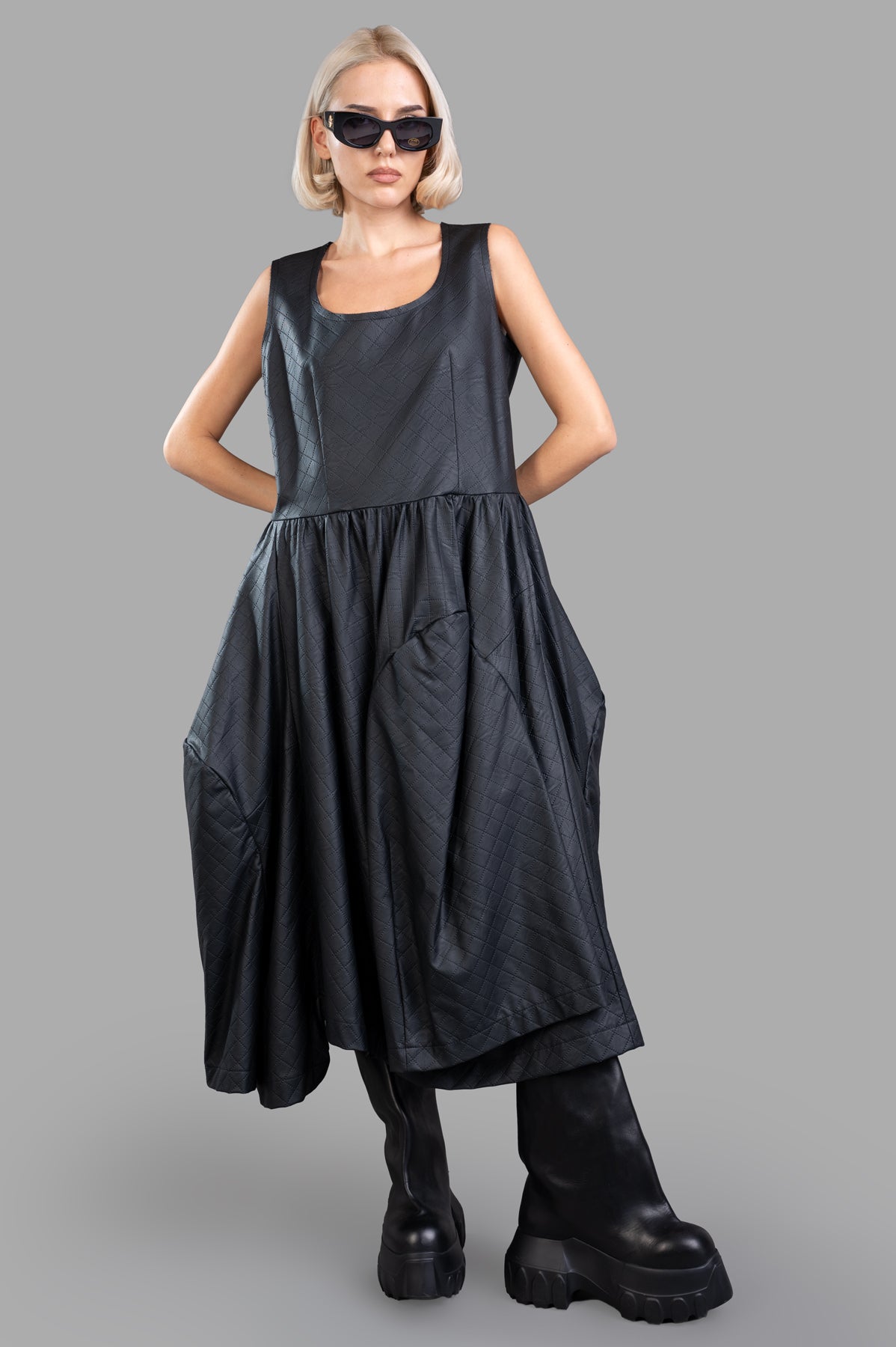 Comme des Garçons black paneled dress in pinafore style, shown from the front with a rounded neckline on-model.