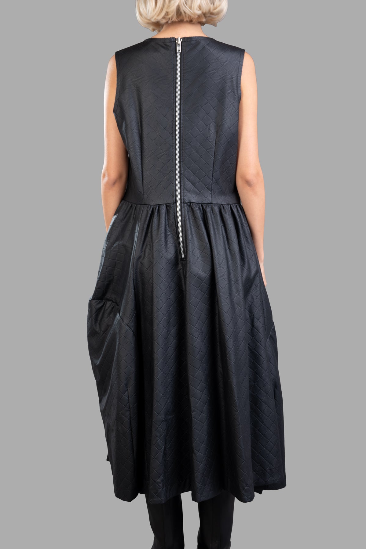 Comme des Garçons Paneled Dress; back view showcasing zip detail, flattering pinafore shape, and textured black fabric.