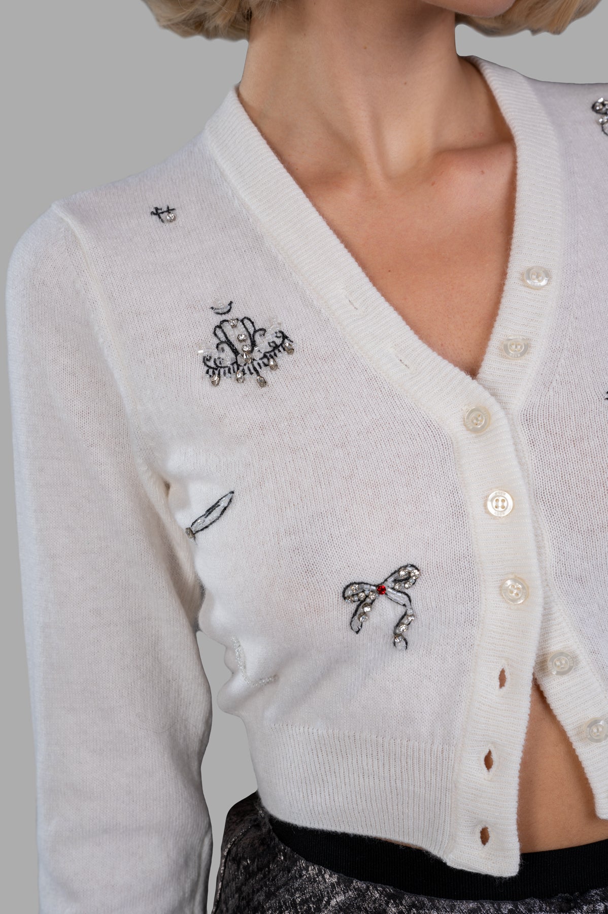 MSGM Embellished Cardigan in white, showcasing sequin details, V-neck, and button closure on a model. Perfect for chilly days.