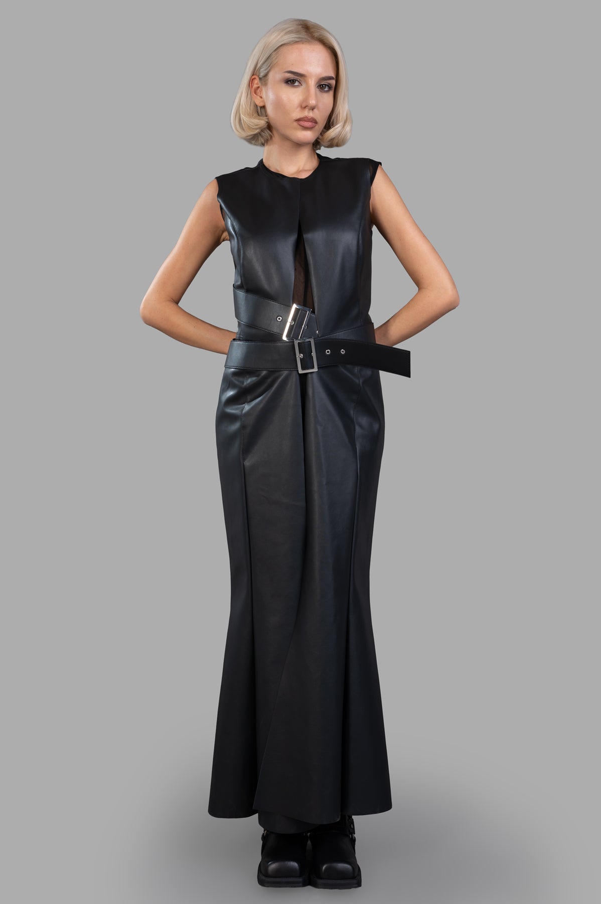 Junya Watanabe Faux Leather Dress front view, black synthetic leather with cut-out waist and pin-buckle detail.