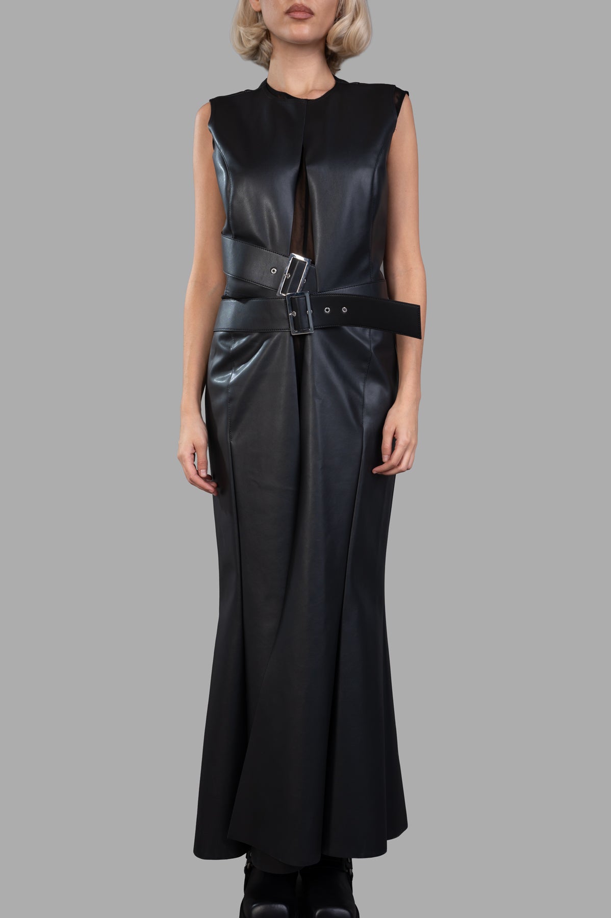 Junya Watanabe faux leather dress featuring a cut-out waist and buckle detail, showcasing a sleek, modern silhouette.
