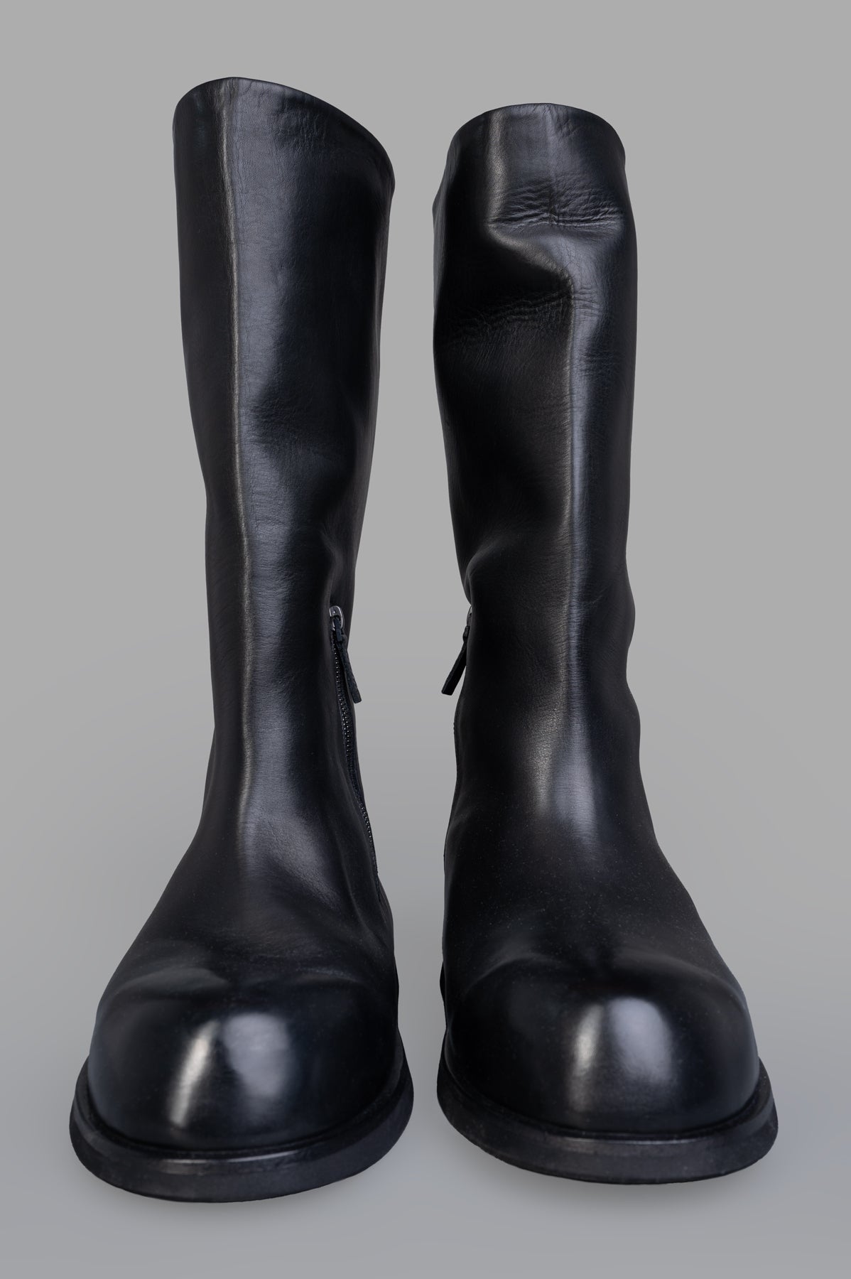 Marsèll Gigante Leather Boots in black, showcasing front view with side zip fastening and smooth leather texture.