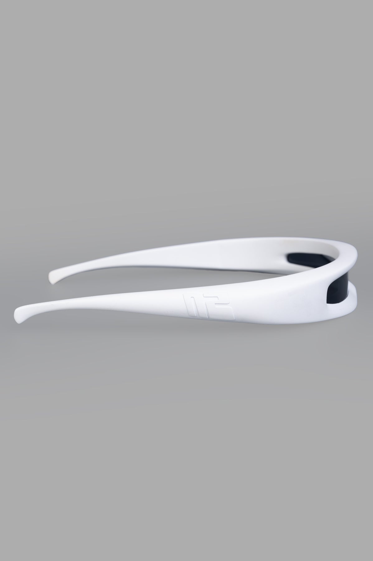 Natasha Zinko Futuristic Sunglasses in white, showcasing a sleek headband design from a side view, emphasizing bold style.