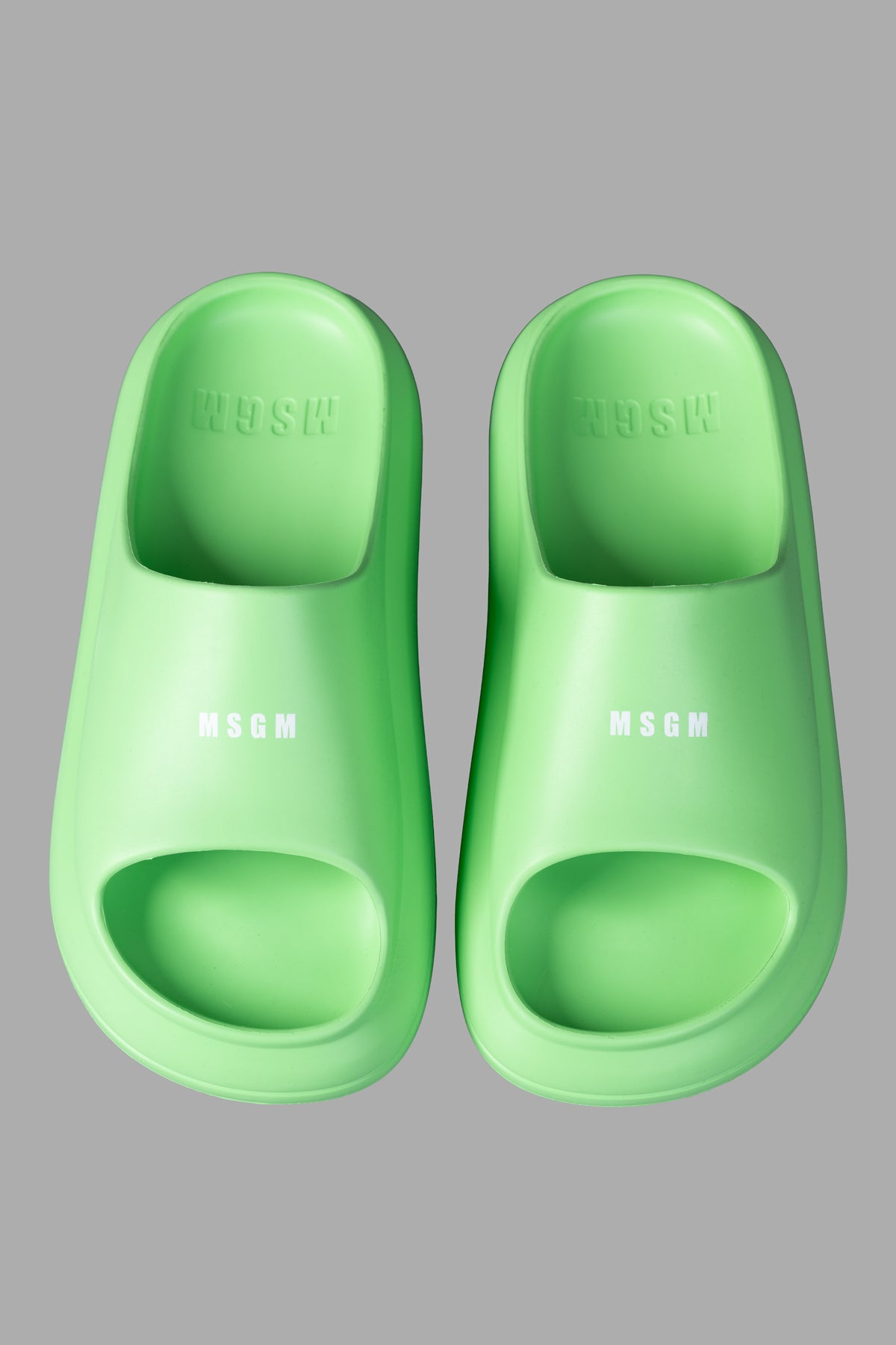 MSGM Ocean Club Sliders in bold green. Close-up view highlights the smooth texture and signature logo on oversized slides.