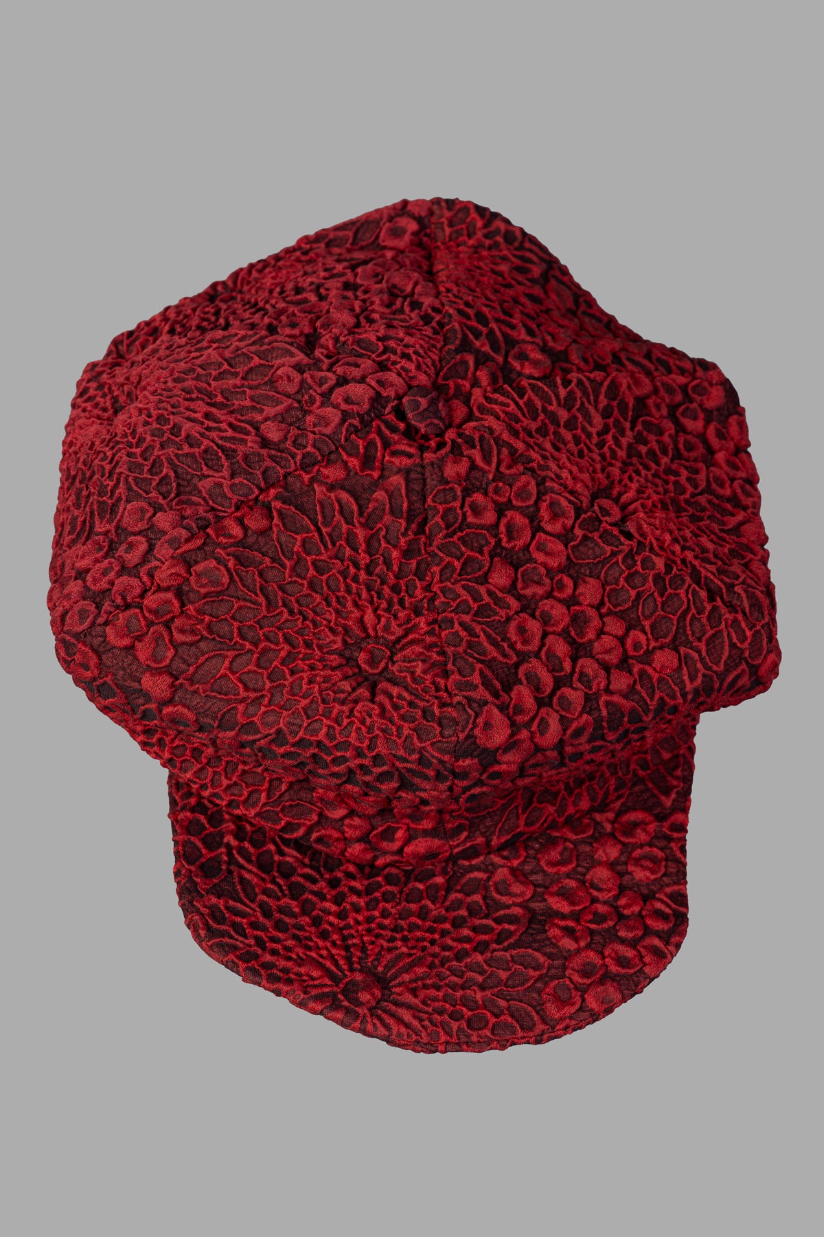 Marc Point Panelled Hat with a Peak showcasing a textured floral print in red, featuring a reinforced peak for added support.