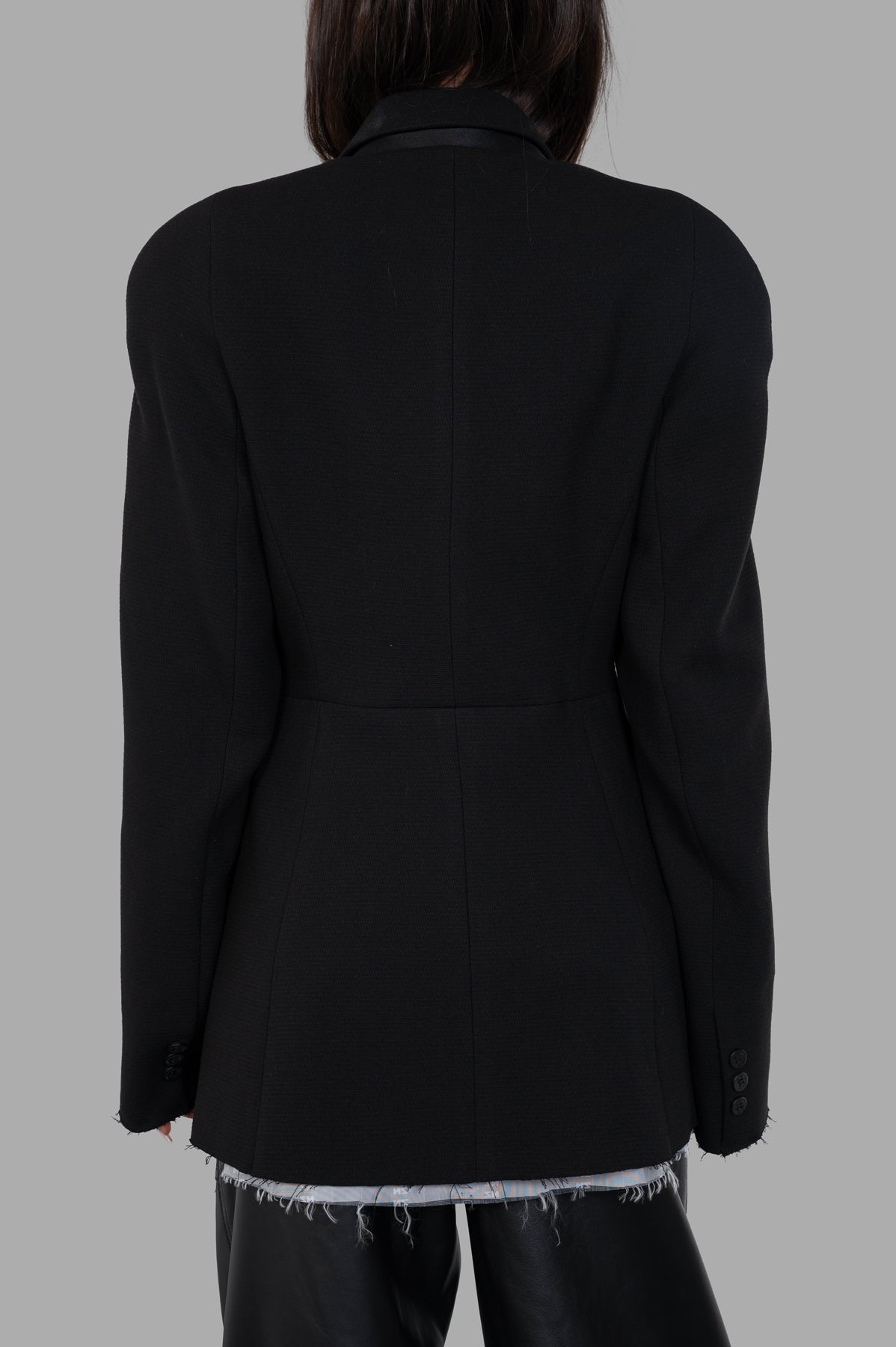 Natasha Zinko Pilot Jacket showcasing the back view, featuring raw hems and tailored silhouette in black fabric.