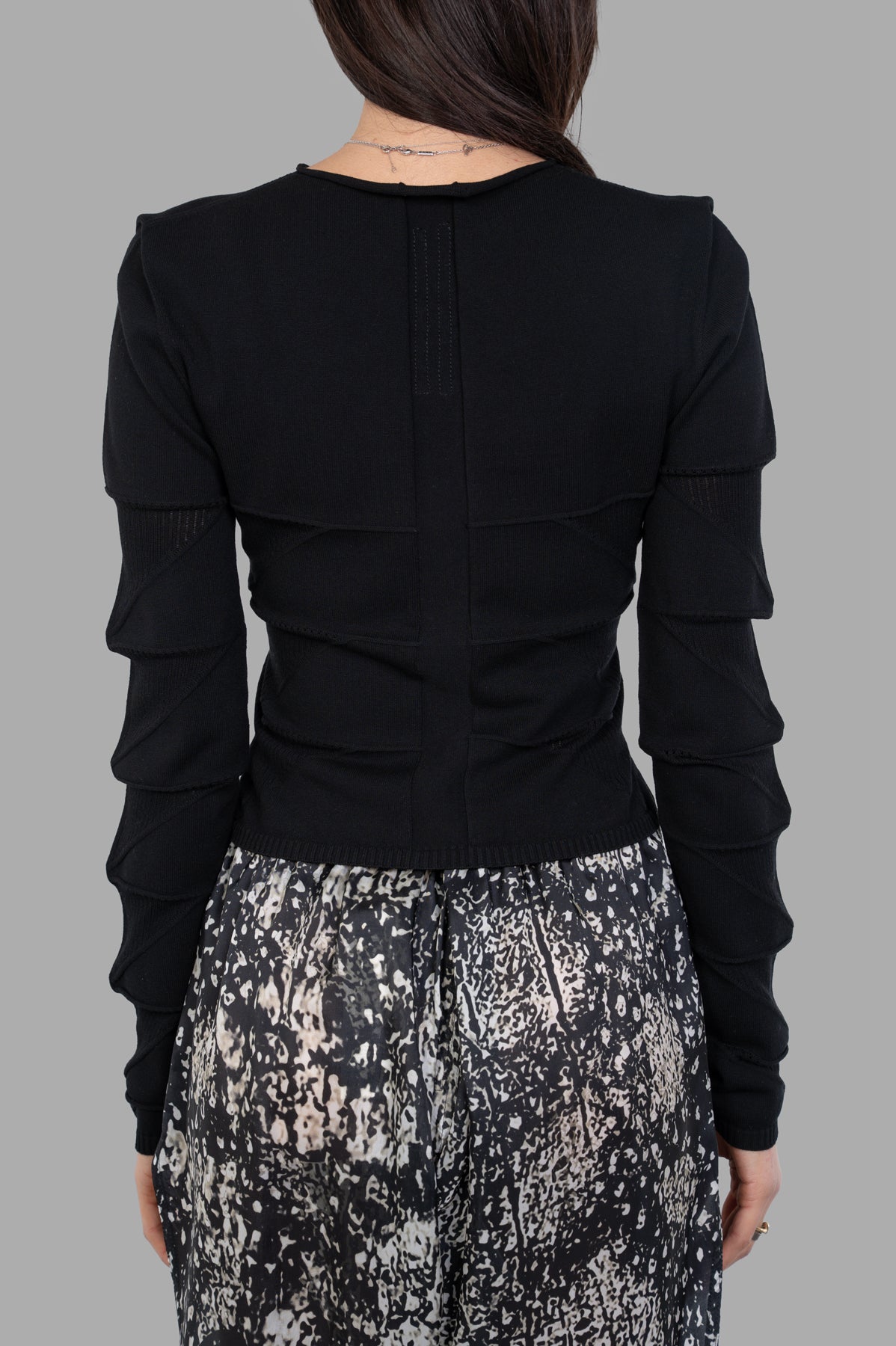 Rick Owens Cropped Knit Blouse showcasing intricate detailing on long sleeves and a flattering fitted silhouette in black.