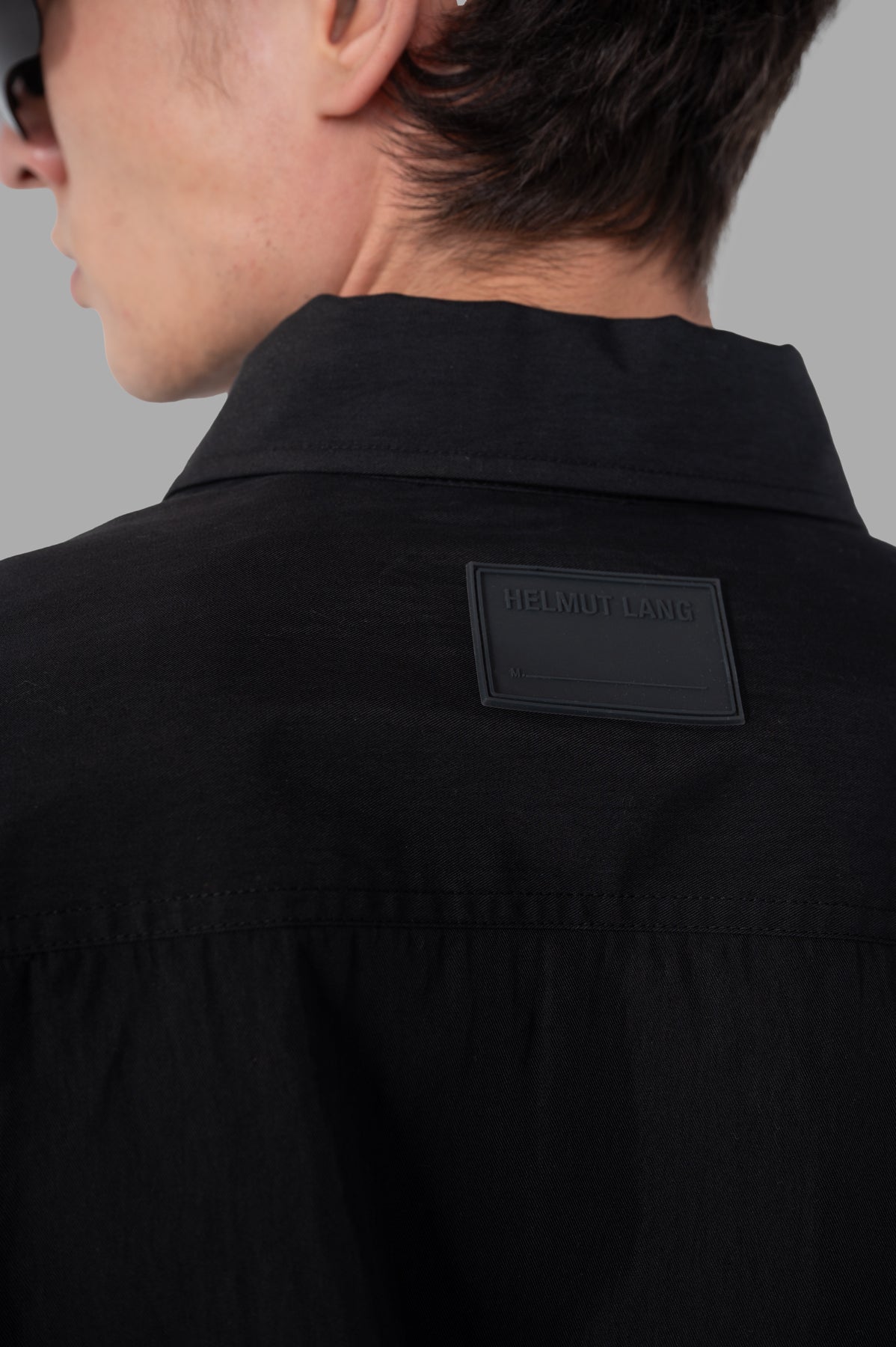 Helmut Lang Uniform Shirt featuring a black cotton-nylon blend with a distinct logo on the back, showcasing sleek design.