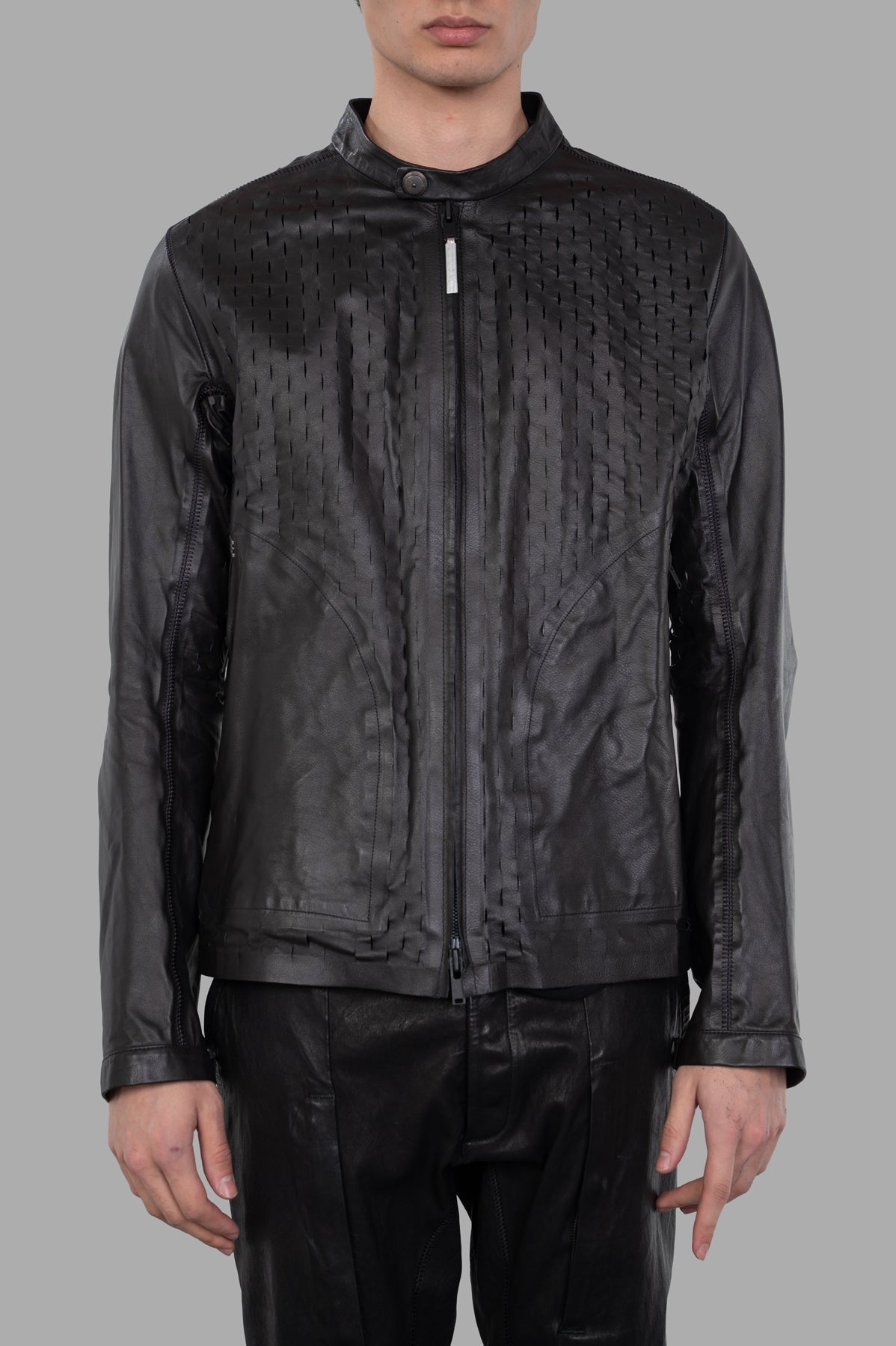 Isaac Sellam Syderal Jacket in black, showcasing laser-cut detailing and bold front zip, worn on model. Elegantly structured.