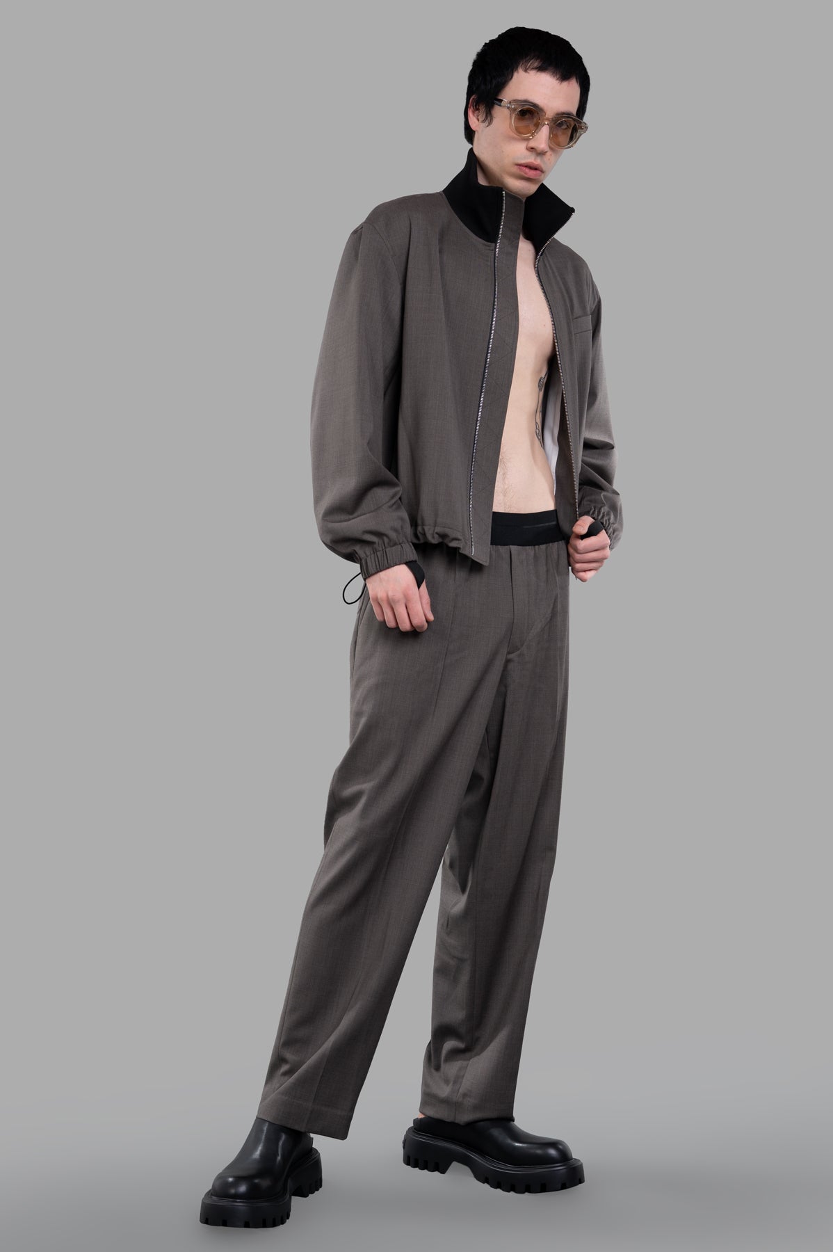 Helmut Lang Relaxed Wool Bomber, front view on model, featuring ribbed collar and utilitarian details in brown virgin wool.