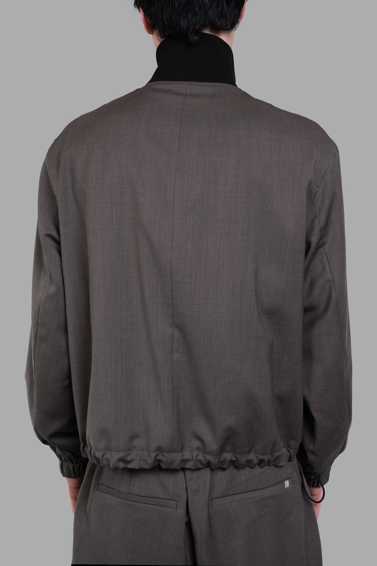 Helmut Lang Relaxed Wool Bomber jacket viewed from the back, featuring ribbed collar and cinched hem in brown wool.
