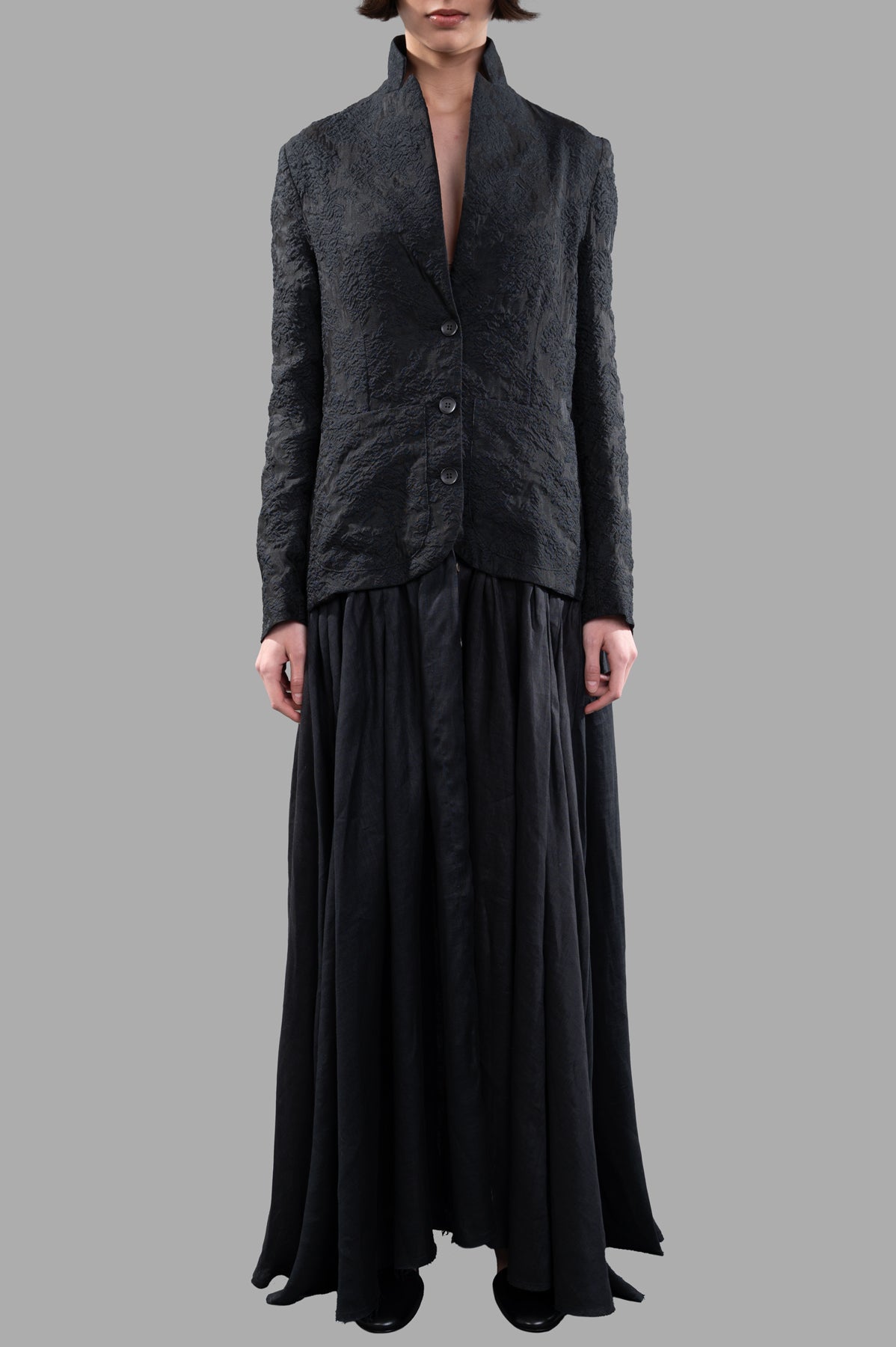 Marc Point Long Dress Coat displayed on model, showcasing textured black fabric and elegant buttoned closure.