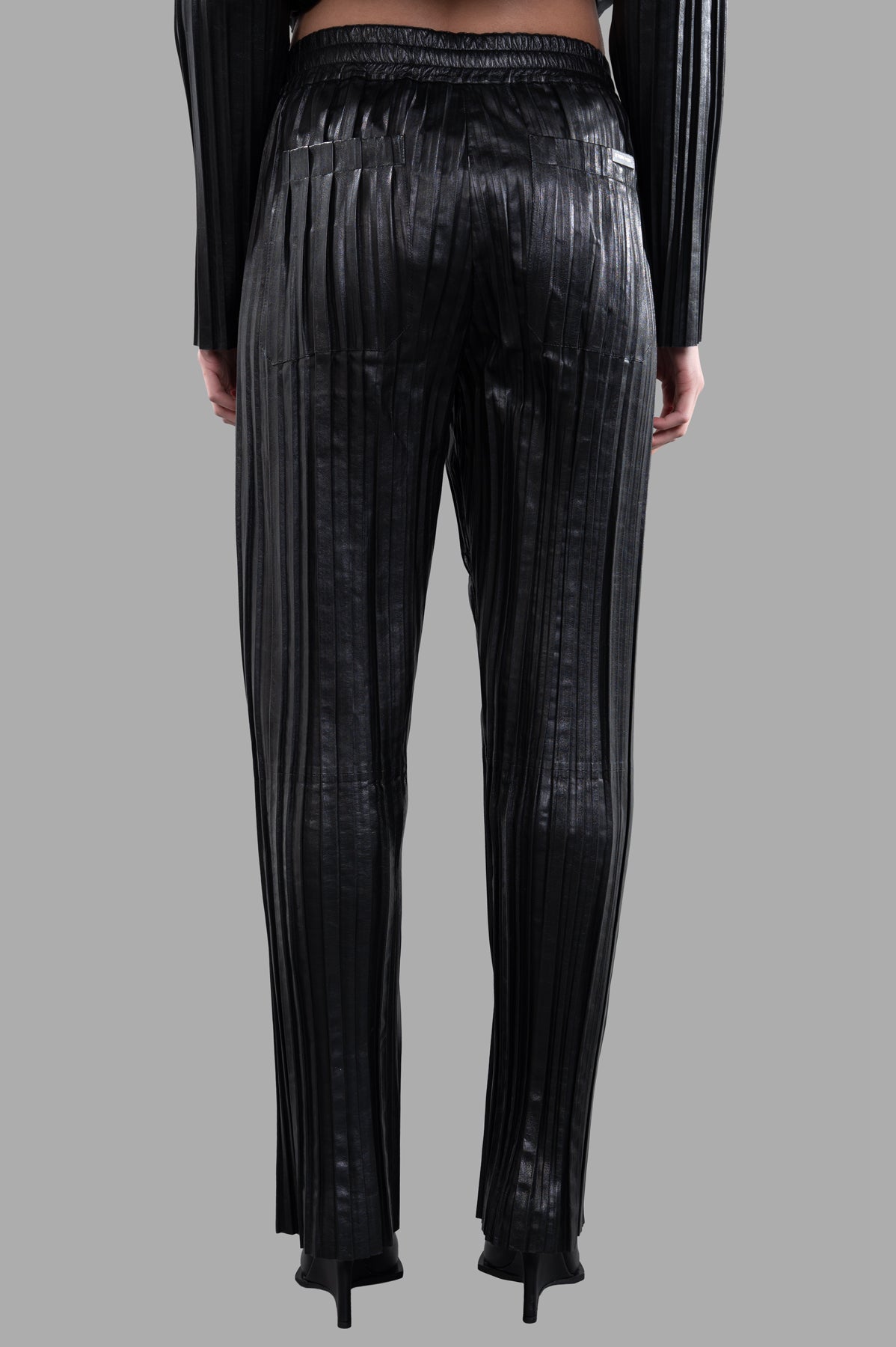 Helmut Lang Pleated Leather Car Trousers showcasing a pleated back design, relaxed fit, and black leather material.