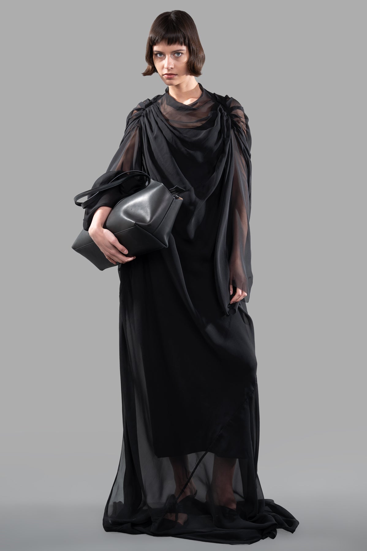 Rick Owens Draped Semi-Sheer Maxi Dress in black, on-model, showcasing ruching and wide sleeves, with a bag detail.