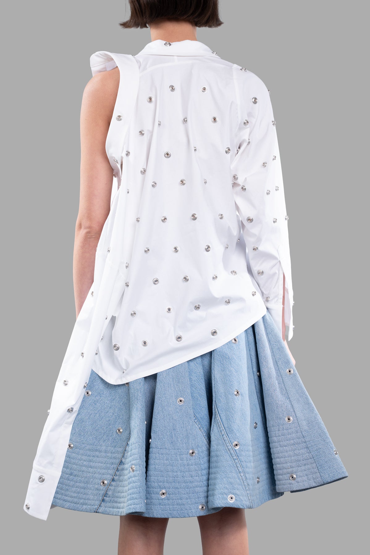 A.W.A.K.E. MODE Studded Double-collar Shirt showcasing the back with silver grommet detailing and a relaxed fit on model.