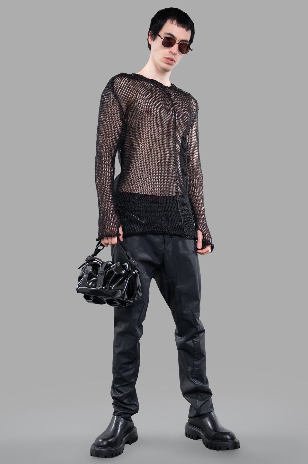 Masnada Mesh Sweater in black, worn-front view. See-through linen design with post-apocalyptic style, perfect for edgy looks.