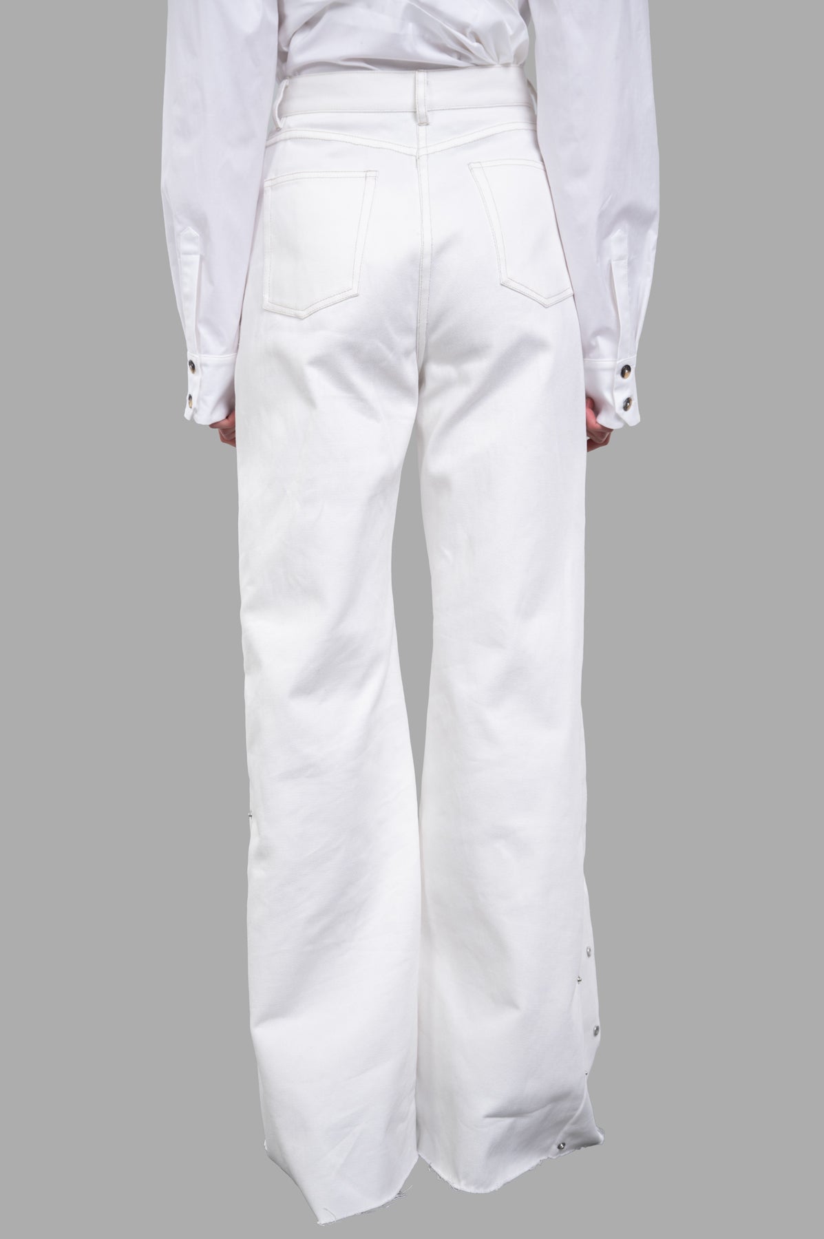 Sehnsucht Atelier Wide-leg Jeans showcase a high-waisted design with metal-button accents, viewed from the back.