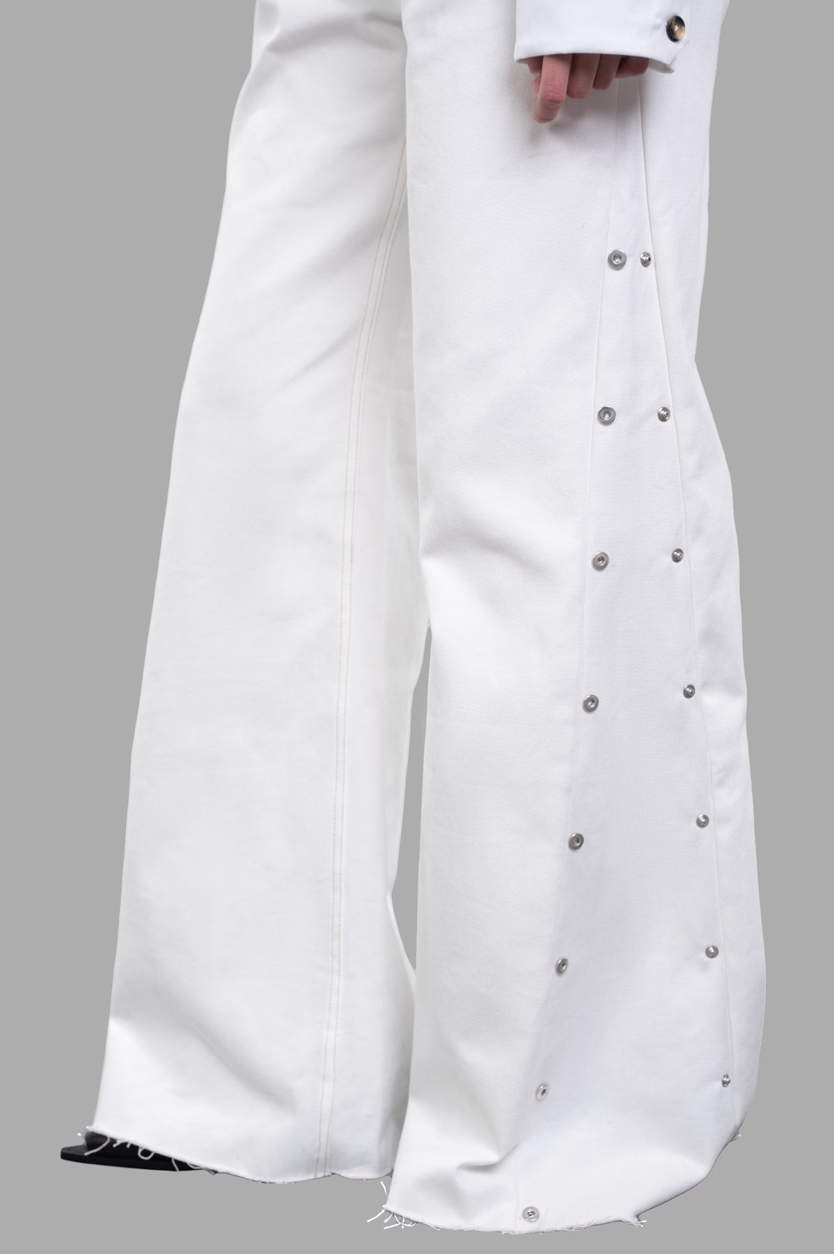 Sehnsucht Atelier Wide-leg Jeans feature metal-button accents and frayed hems, showcasing high-waisted white denim fabric.