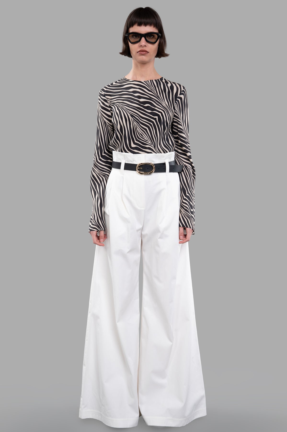 A.W.A.K.E. MODE wide-leg pants, front view, featuring a pleated paper bag waist and slant hip pockets, in white cotton.