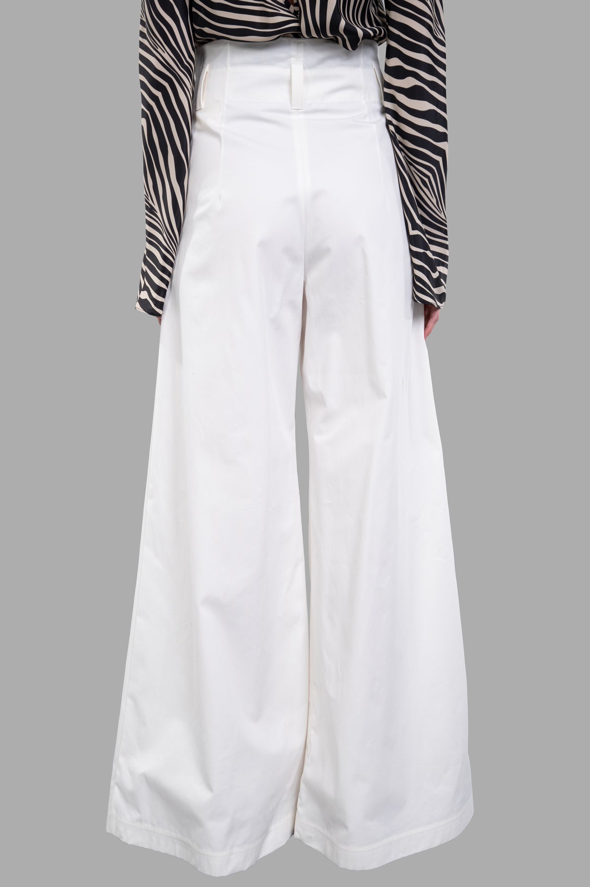 A.W.A.K.E. MODE wide-leg pants in white, highlighting the flattering silhouette and textured pleats, worn by a model.