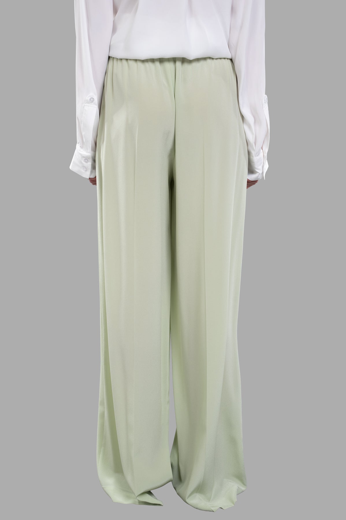 Joseph Crepe de Soie Silk Trousers in matcha, showcasing a wide-leg design and subtle central-pressed creases, back view.