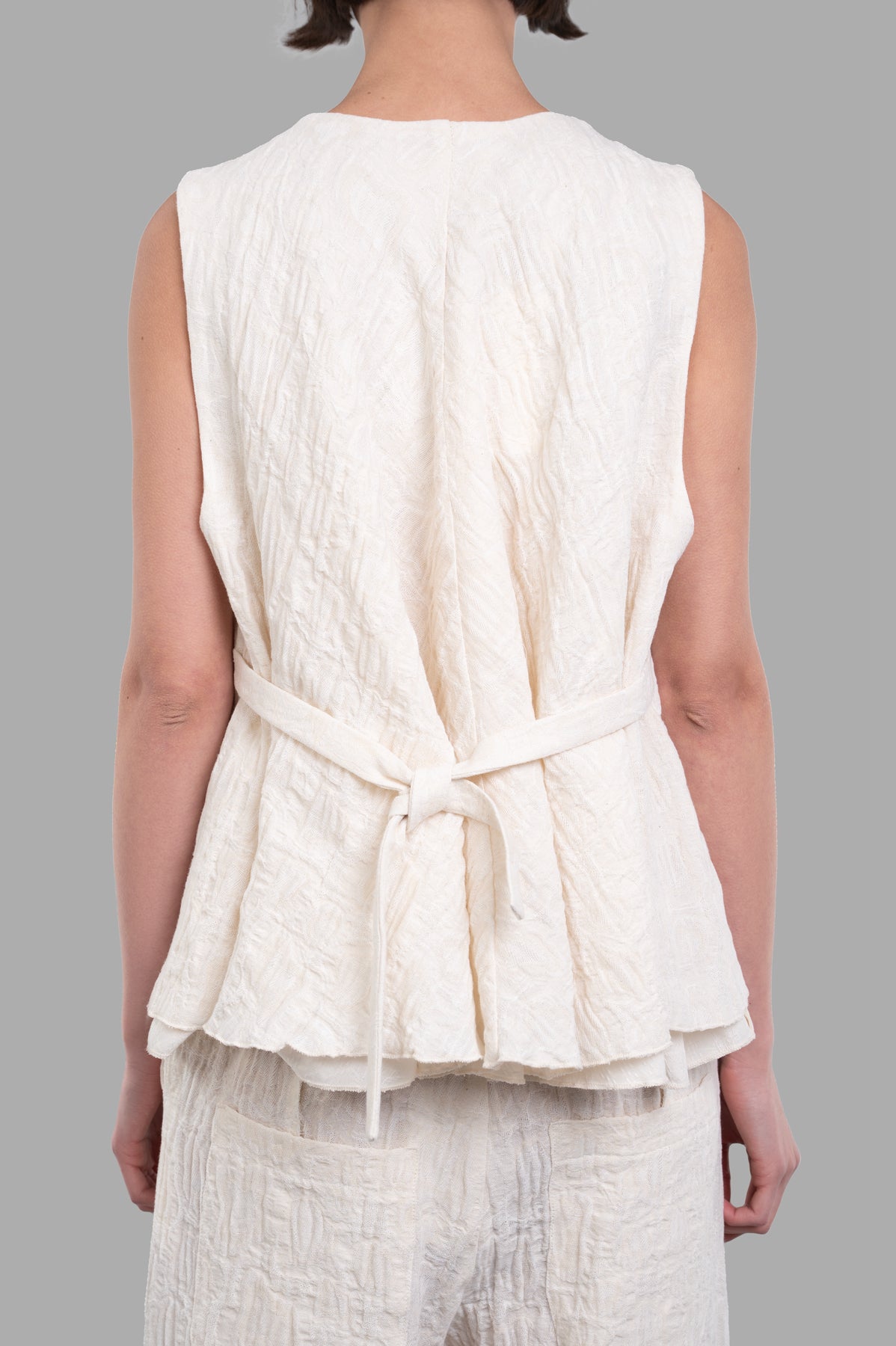 Marc Point Textured Vest displayed from the back, featuring an A-line cut and textured ecru fabric.