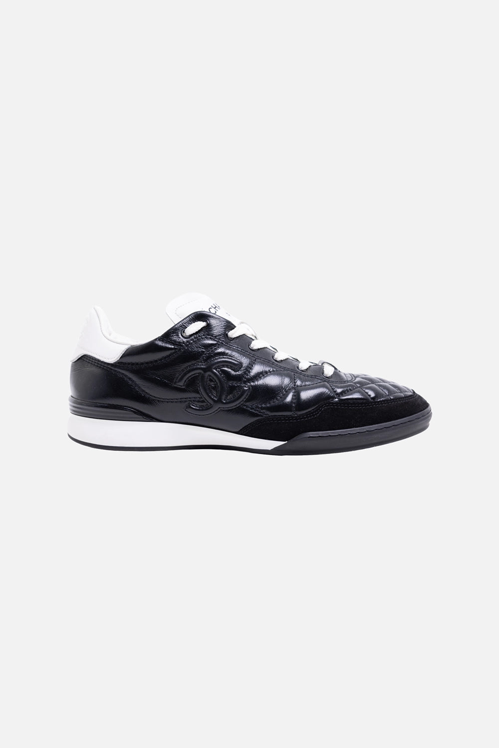 Pre-owned Chanel women’s low-top sneakers in black and white, side view, quilted CC logo panel