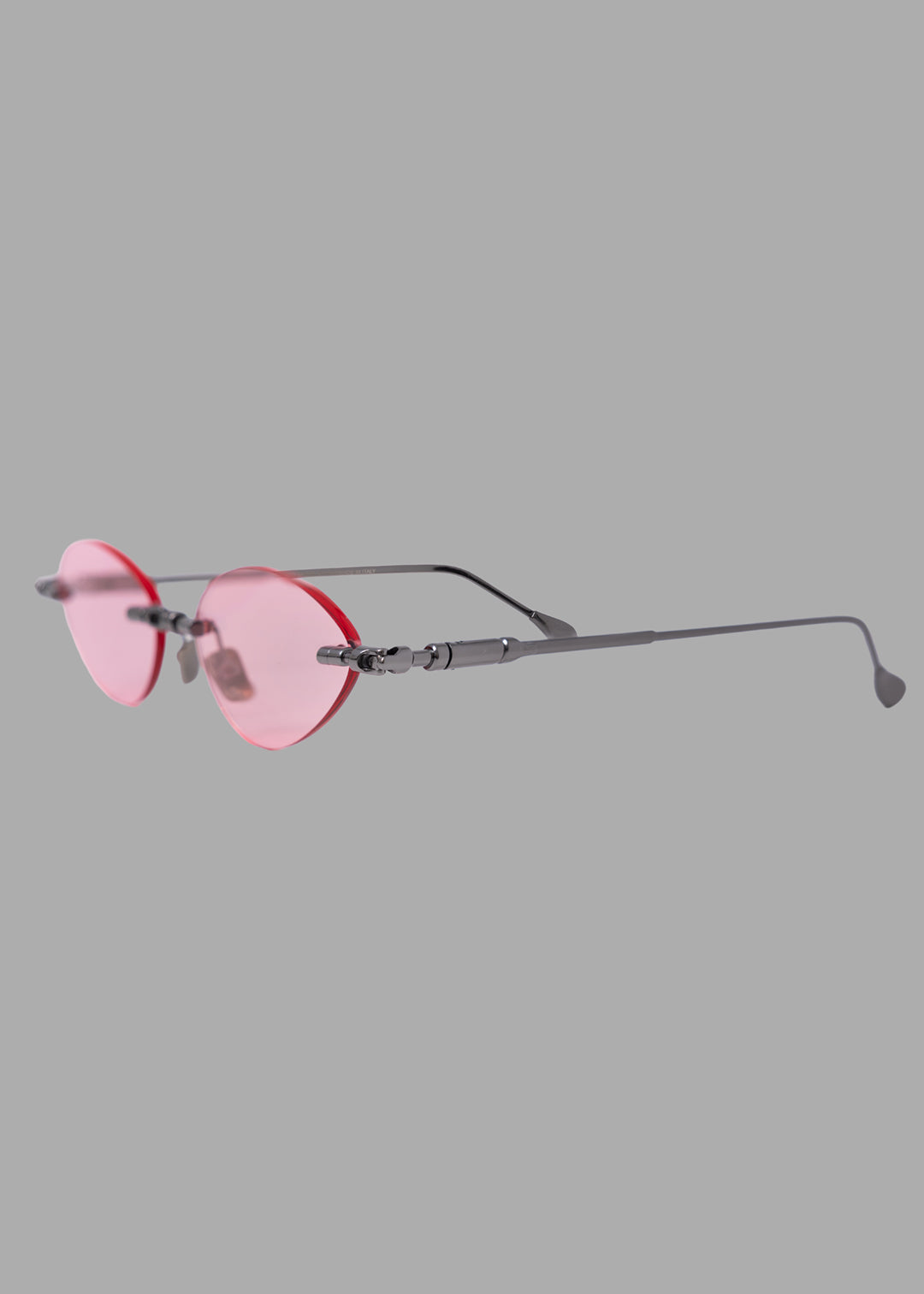 Kuboraum unisex gunmetal sunglasses with light pink lenses, three-quarter side view showing linked metal bridge detail.