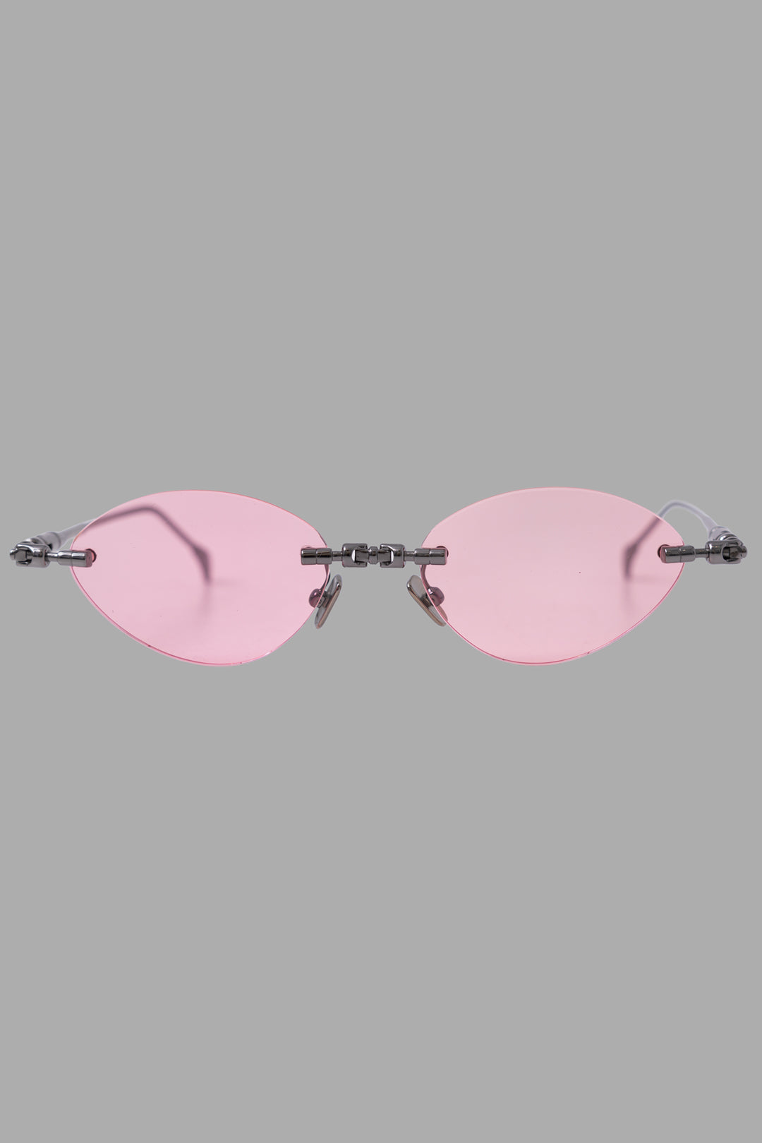 Kuboraum unisex rimless sunglasses with light pink lenses and gunmetal temples, front view with narrow cat-eye shape.