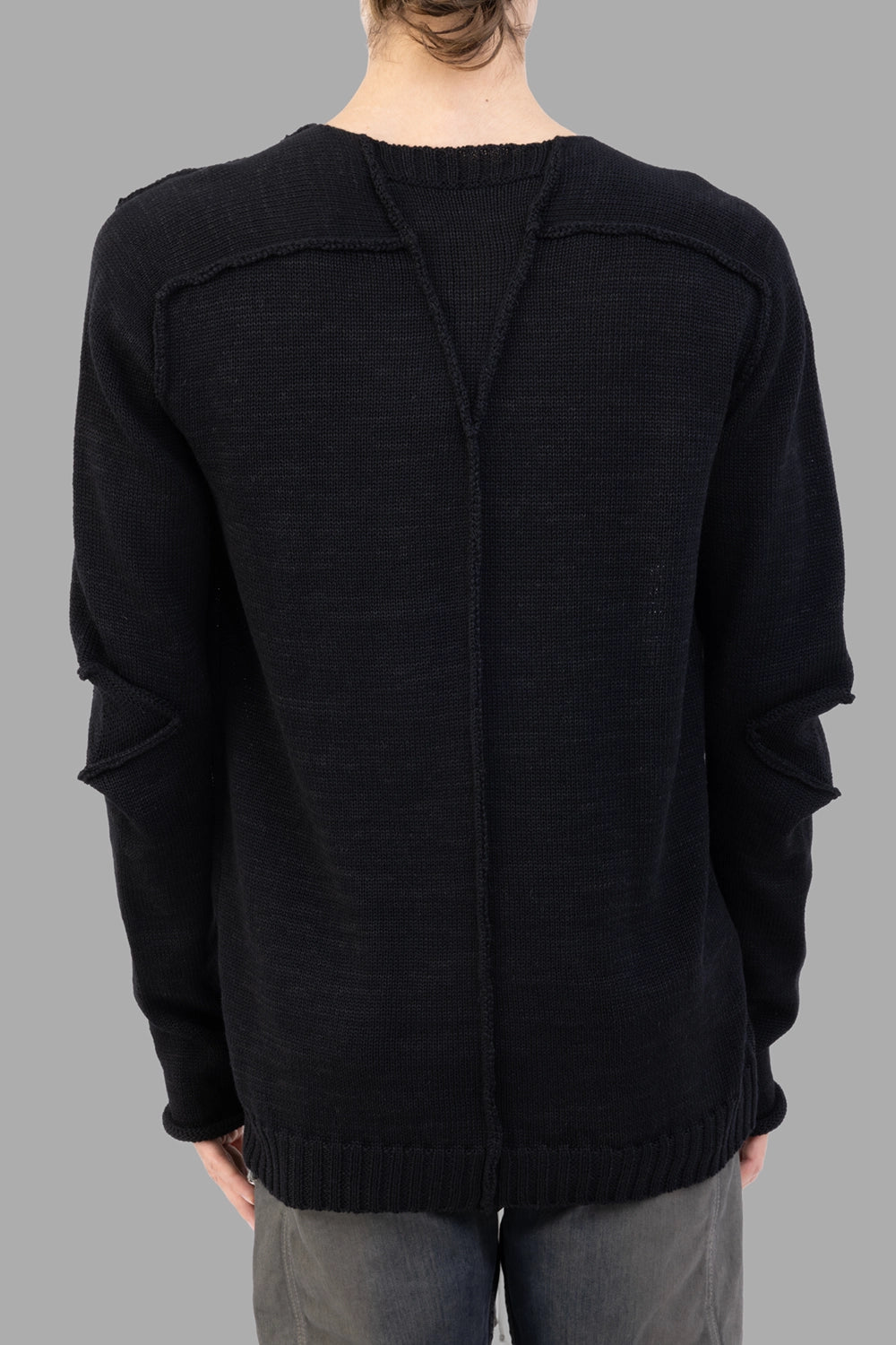 Masnada black sweater, back view, exposed center seam and rib hem