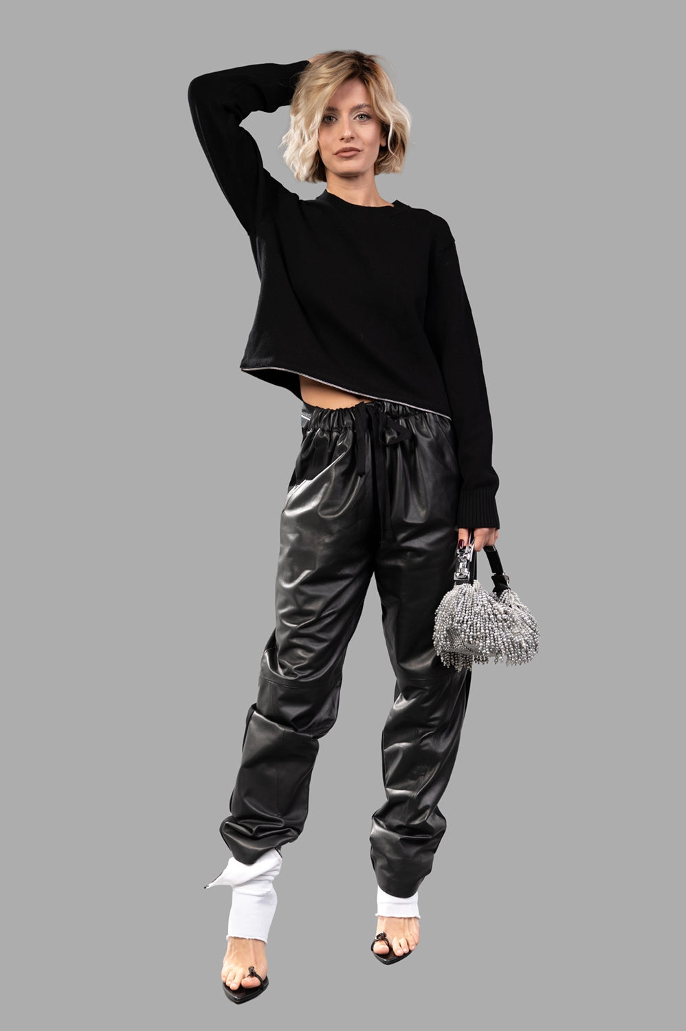 Model in black cropped crewneck sweater with zip hem, full-length view, ribbed cuffs