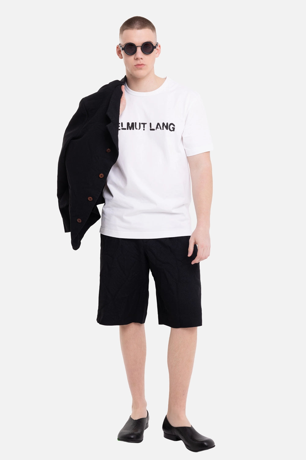 Helmut Lang men's white T-shirt, on-model full-length view, black stencil chest logo and crewneck
