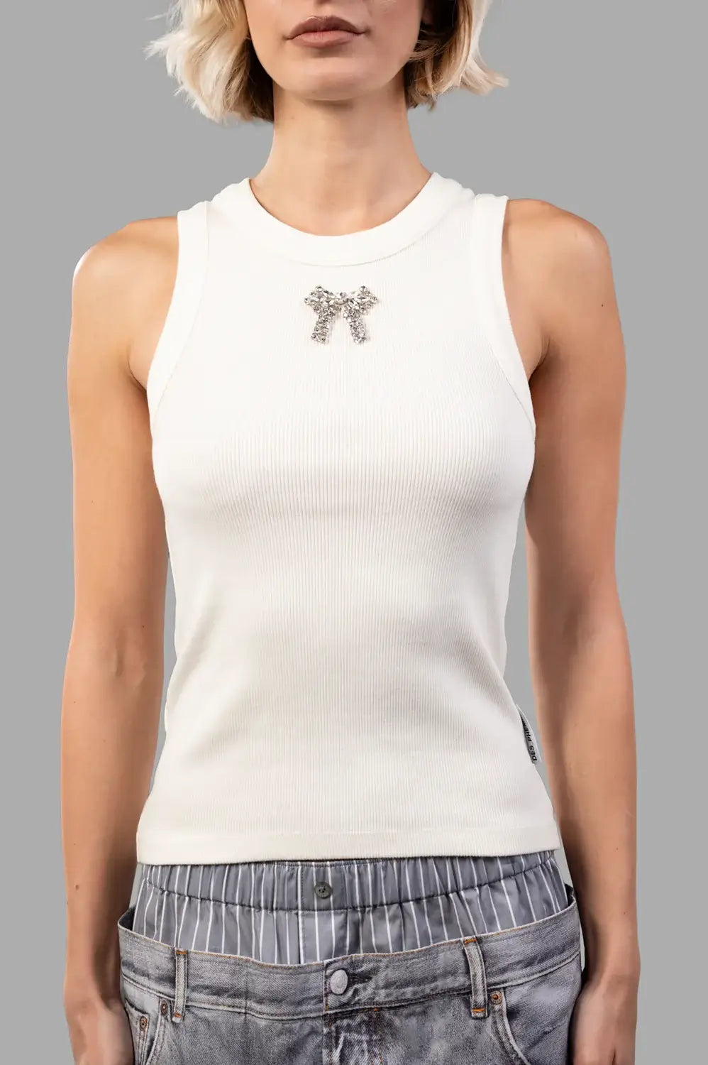 Front close-up of creme ribbed tank; round neck with wide binding and crystal bow at center
