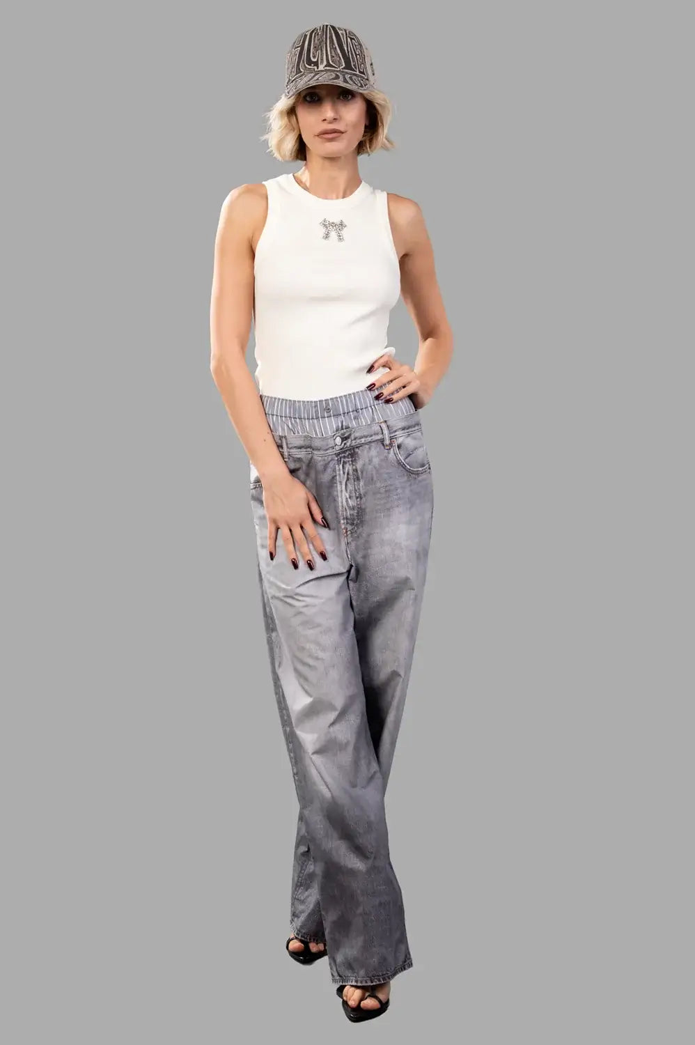 Full-length view of a creme ribbed tank top with crystal bow detail, fitted silhouette
