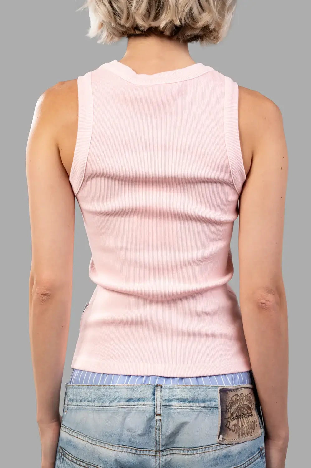 Back view of light pink ribbed tank showing clean finish and close fit