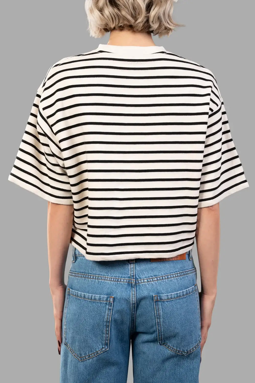 Back detail view of cropped striped tee featuring dropped shoulder seam and clean knit finish