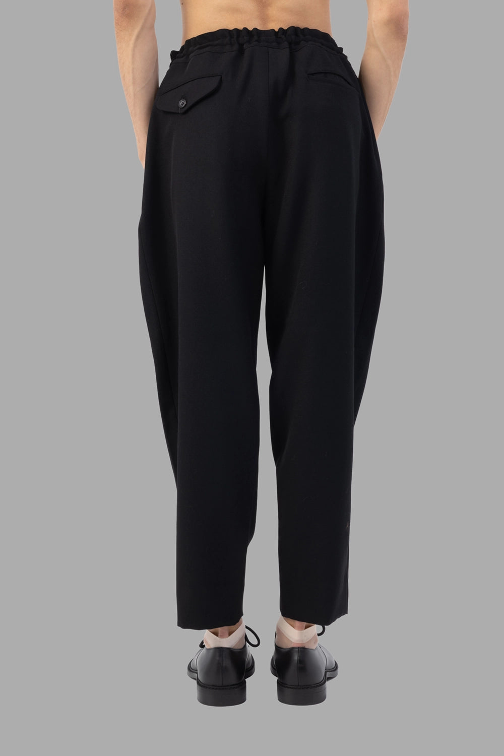 Comme des Garçons trousers in black, back view, flap back pocket visible