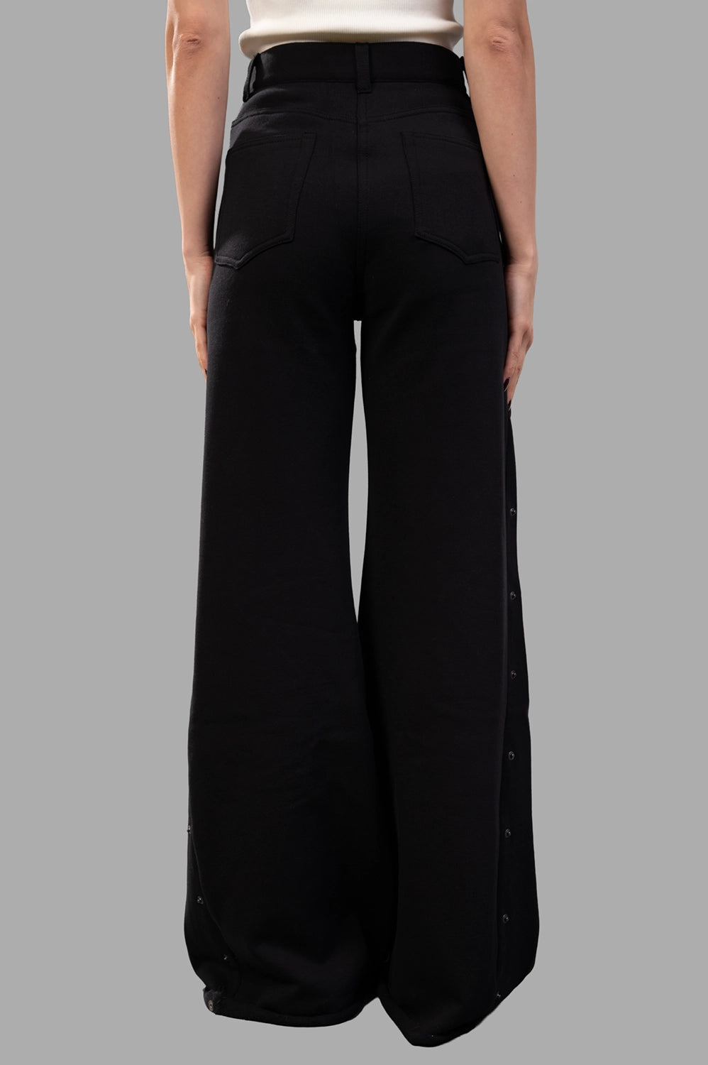 Sehnsucht Atelier wide-leg trousers in black, back view with patch pockets and clean yoke