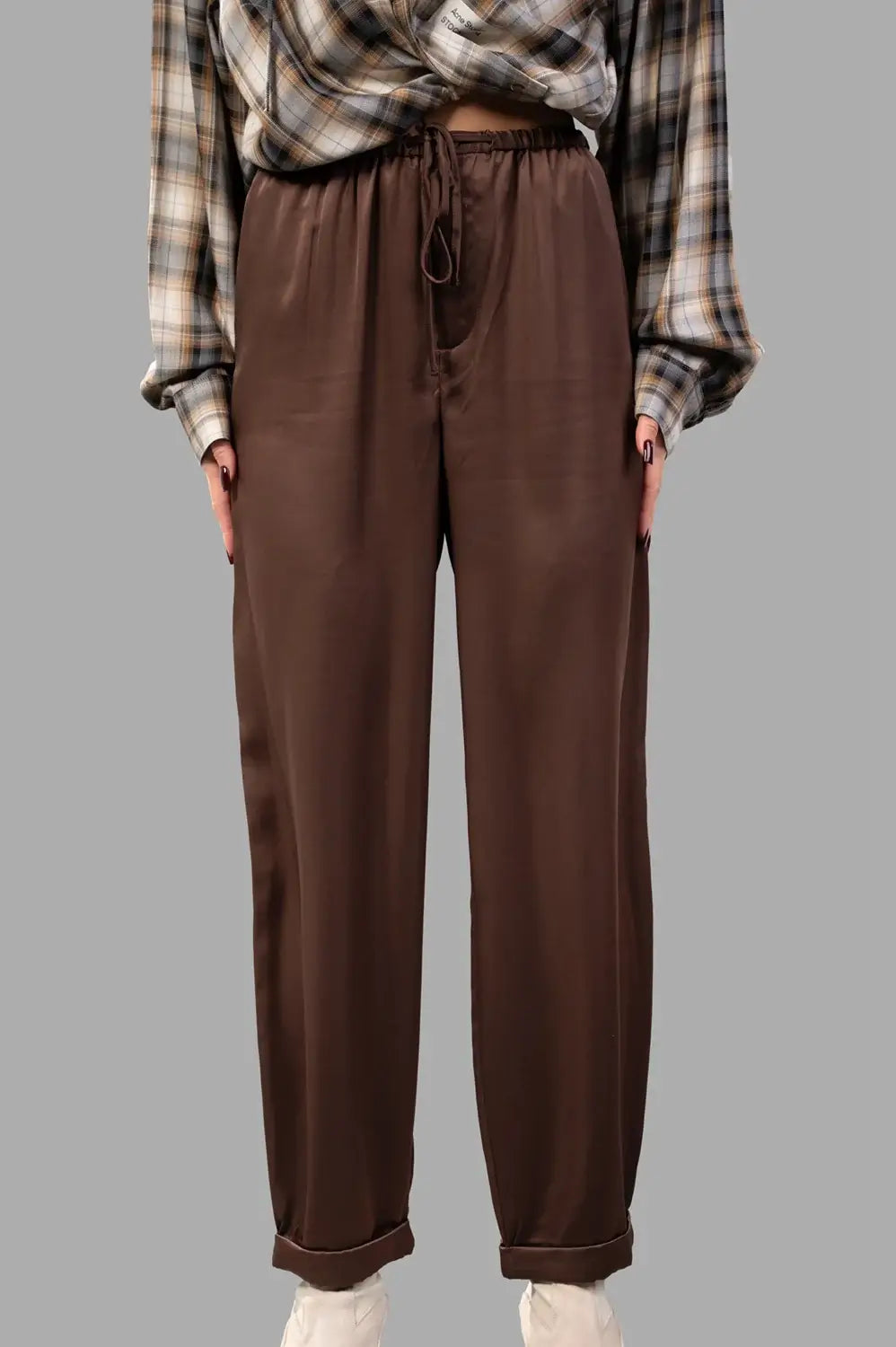 Front close-up of brown satin trousers with drawstring waist, zip fly and smooth finish