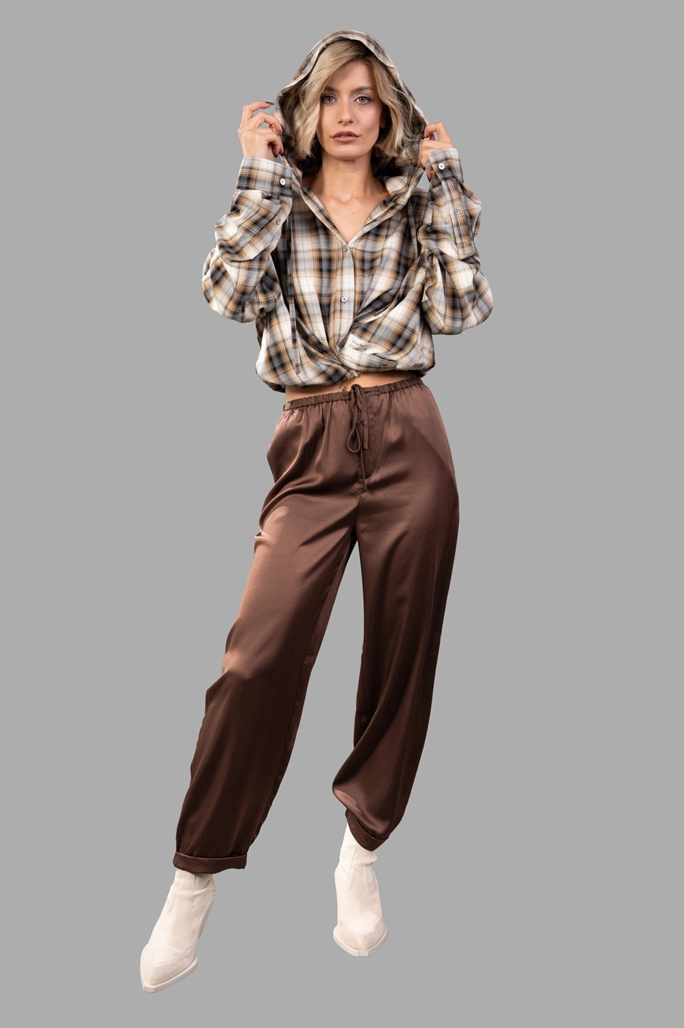 Brown satin drawstring trousers on model, relaxed wide legs with folded cuffs