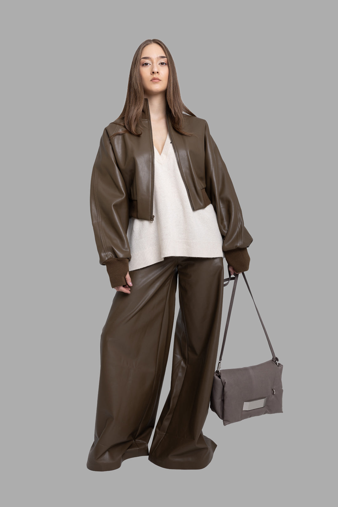 Norma Kamali women's bark vegan leather bomber jacket, on-model full length, oversized fit styled with wide-leg pants.