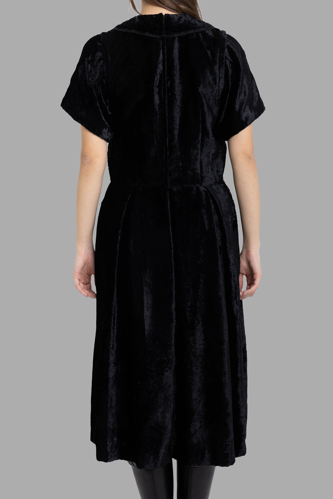 Comme des Garçons women's black velvet midi dress, back view showing subtle volume and clean waist seam.