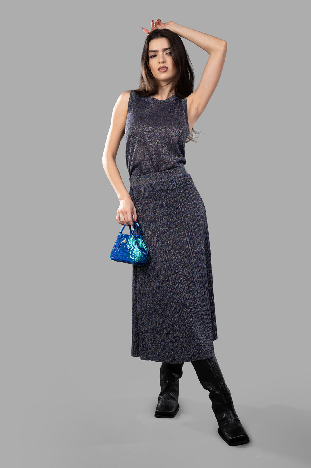 Joseph Metallic Fibre Knit Skirt in Aurora purple, A-line ribbed texture, styled with matching top, model holding blue bag.