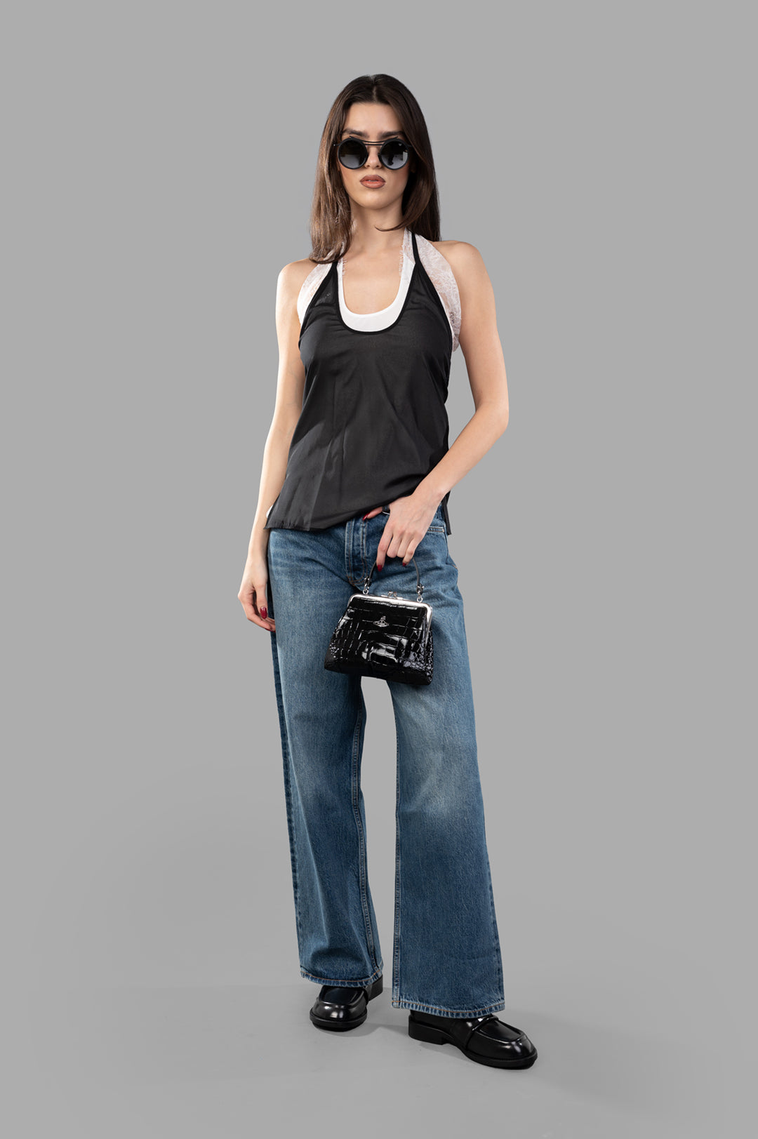 Helmut Lang Lace Dancer Top in black, front view on model, featuring adjustable neck strap, paired with jeans and a handbag.