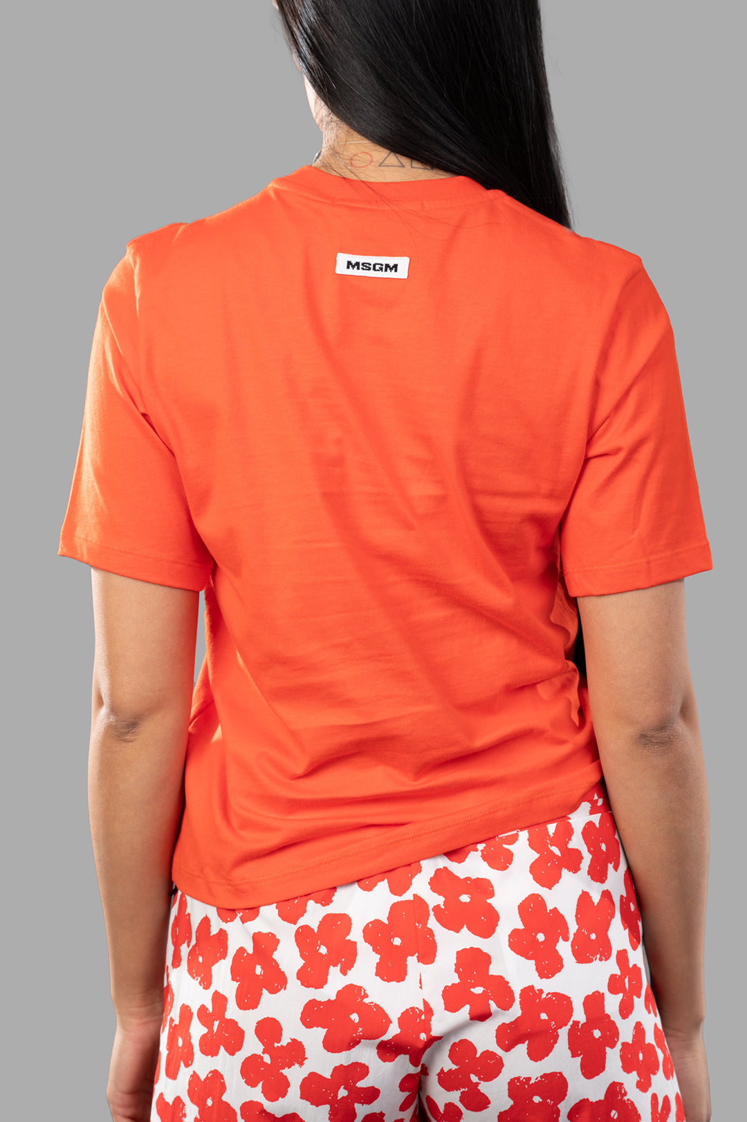 MSGM Gathered T-shirt showcasing the back view, featuring rib-knit fabric and asymmetric hem in vibrant orange.